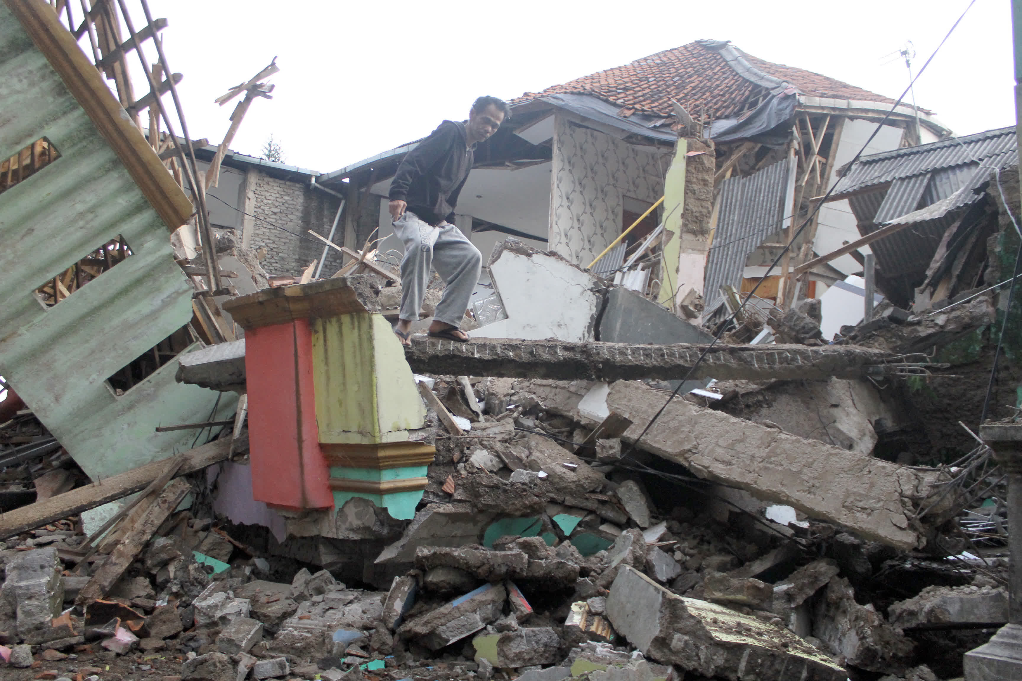 11月21日，一名男子在印度尼西亞西爪哇省展玉查看被地震損毀的房屋。（新華社）