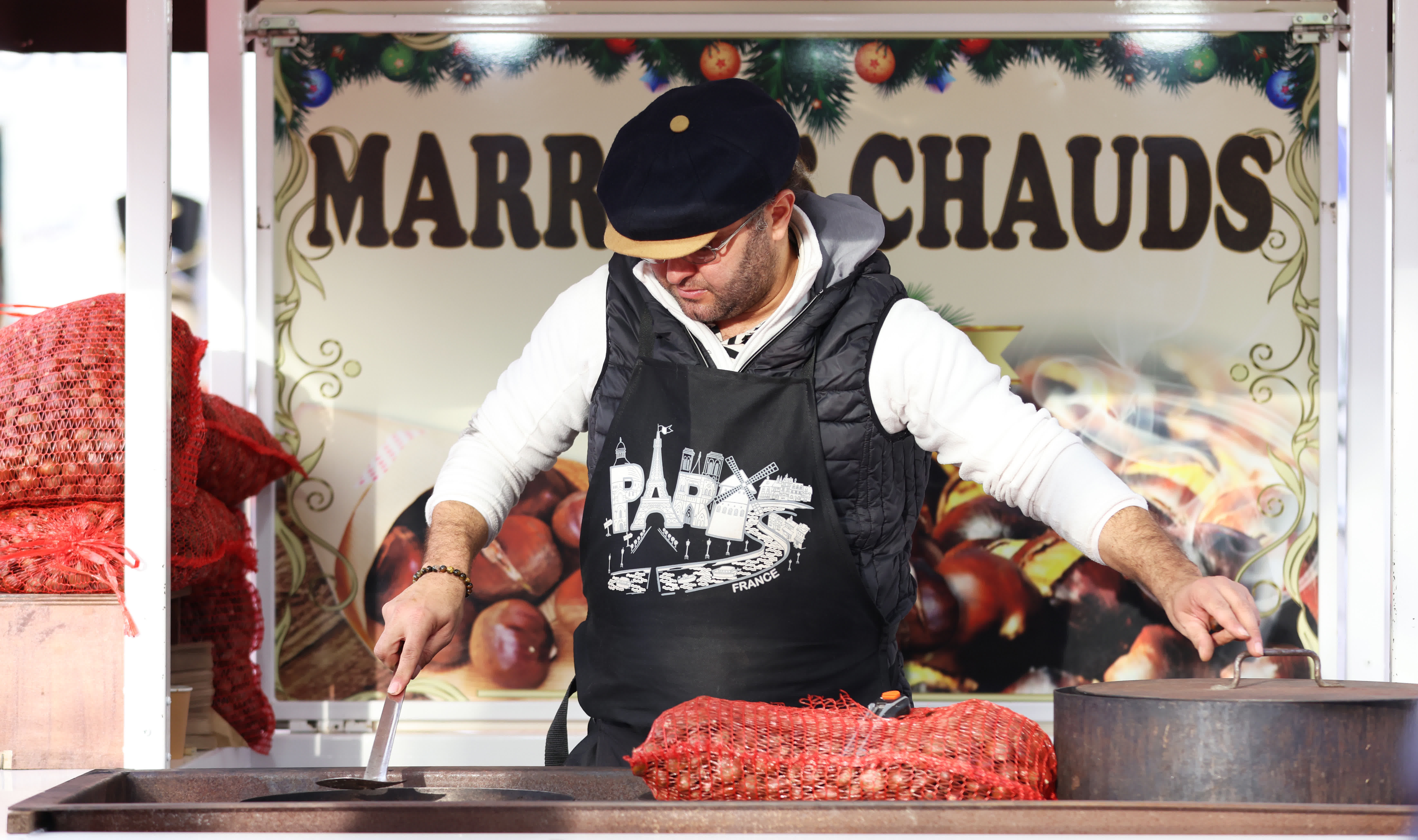 11月24日，商販在法國巴黎杜伊勒里花園的聖誕市場售賣熱栗子。（新華社）