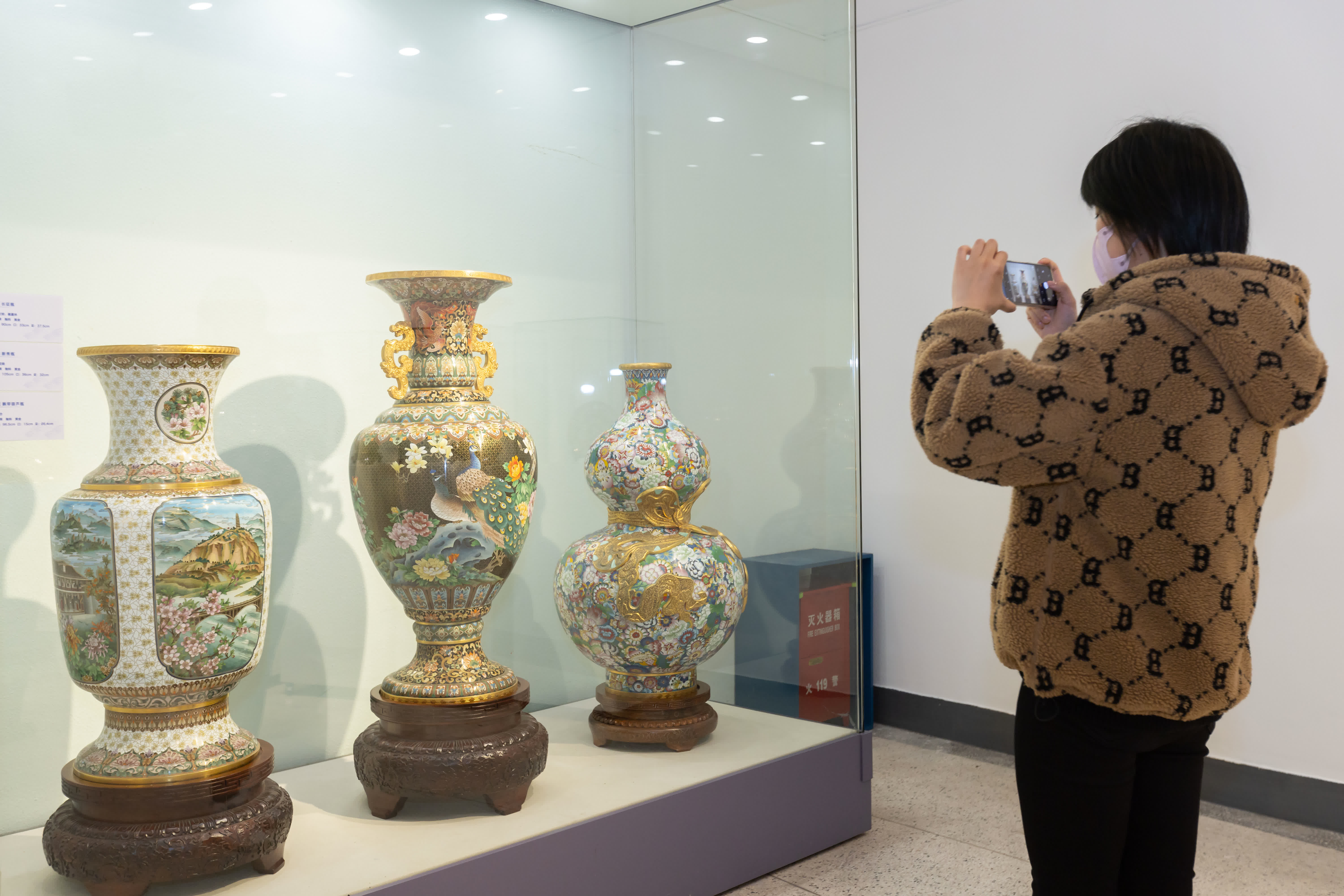 12月3日，觀眾在上海藝術品博物館參觀拍攝景泰藍展品。（新華社）