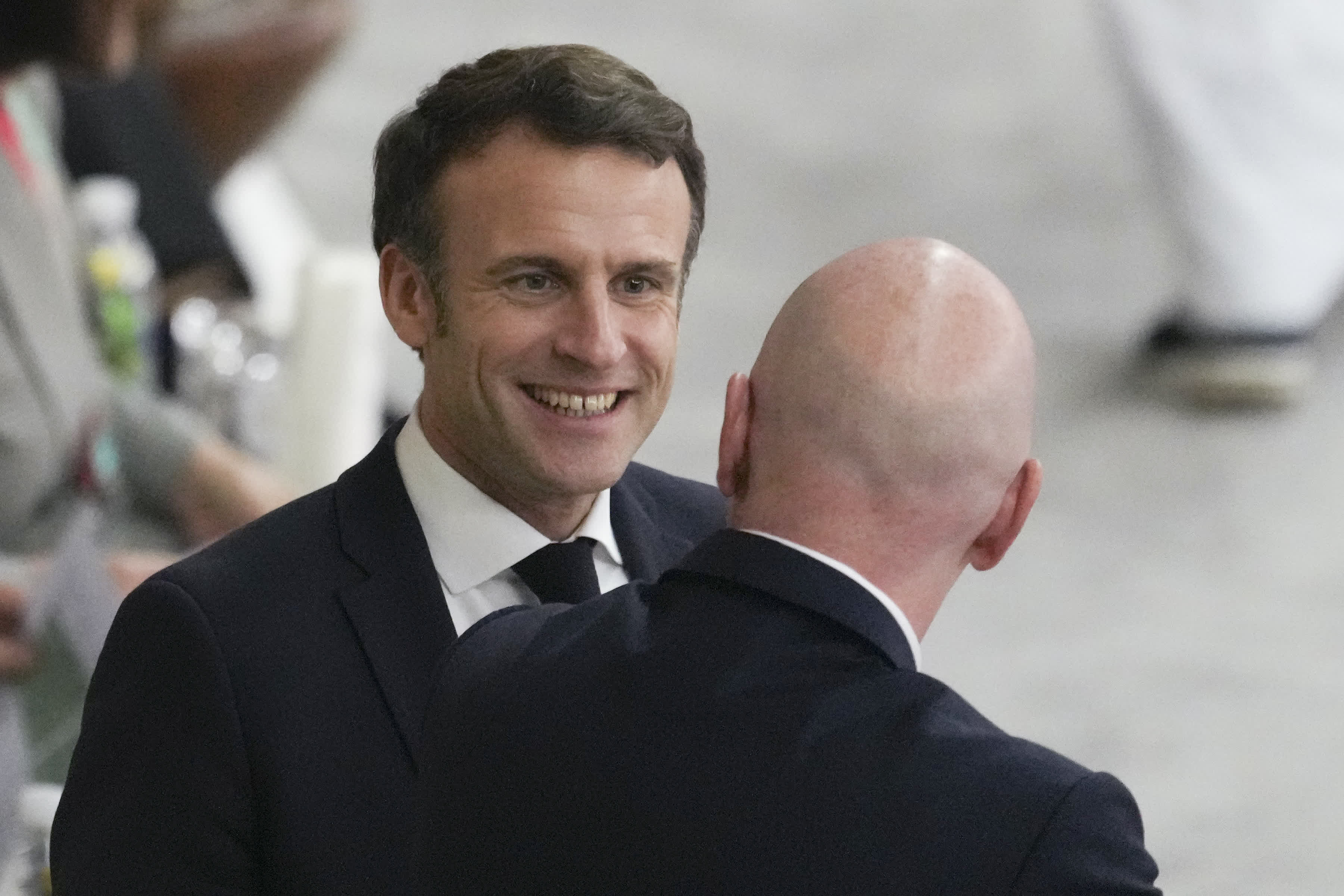 法國總統馬克龍（左）與國際足聯主席因凡蒂諾在比賽前交流。（新華社）