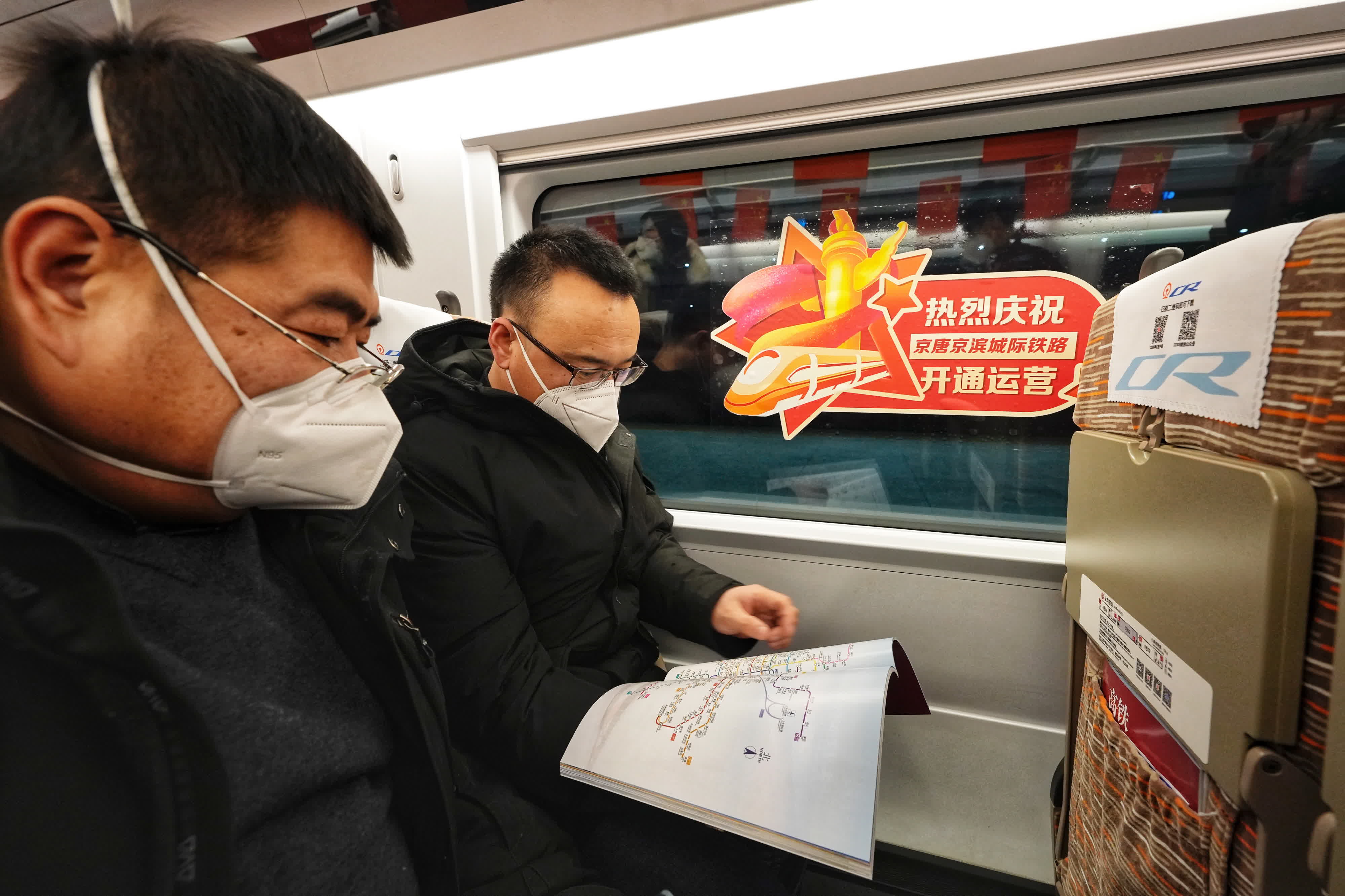 唐山開往北京的首趟G8802次列車上的旅客。（新華社）