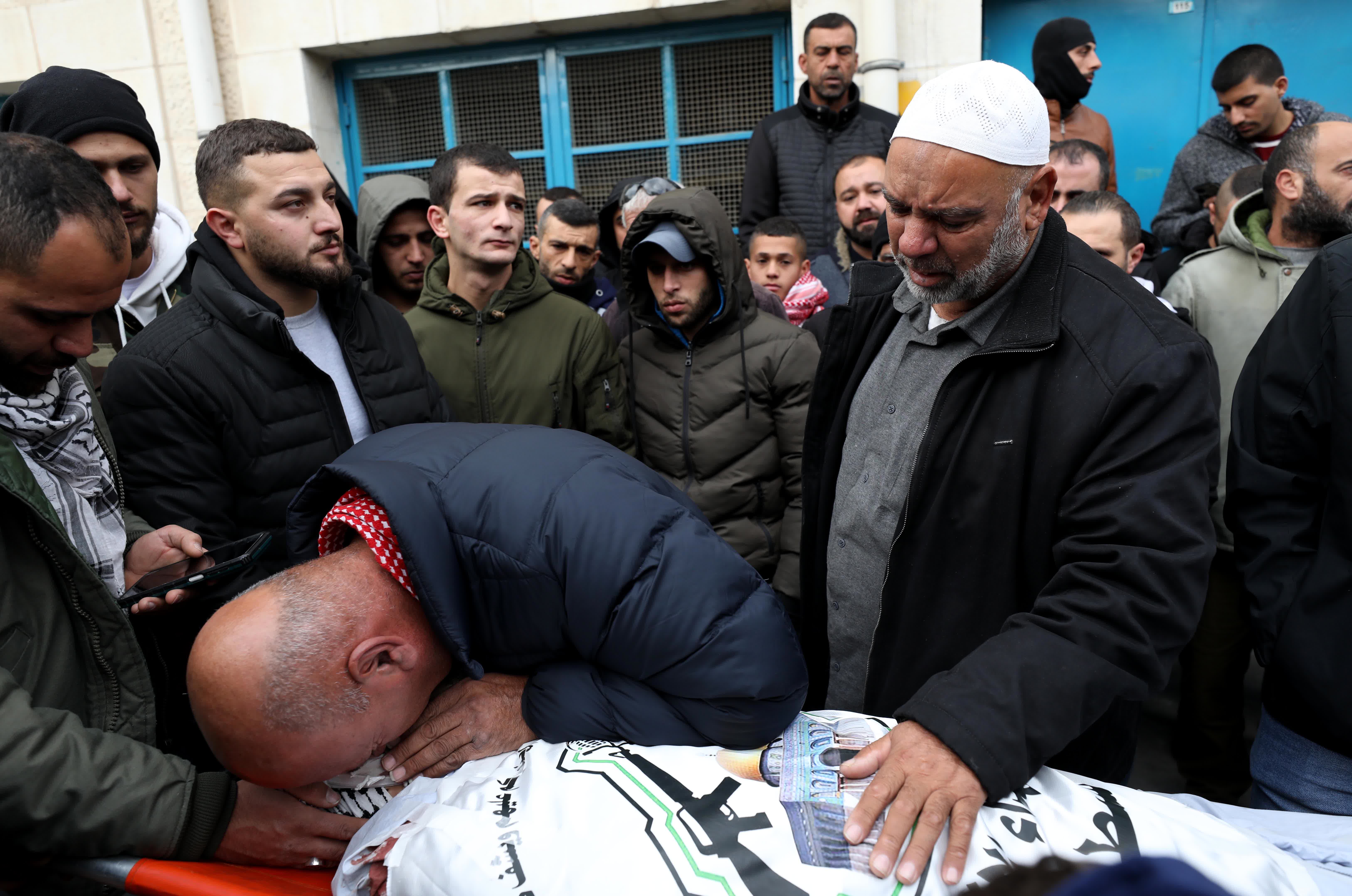 1月2日，在約旦河西岸北部城市傑寧，人們在被以色列軍隊打死的巴勒斯坦人遺體邊哀悼。（新華社）
