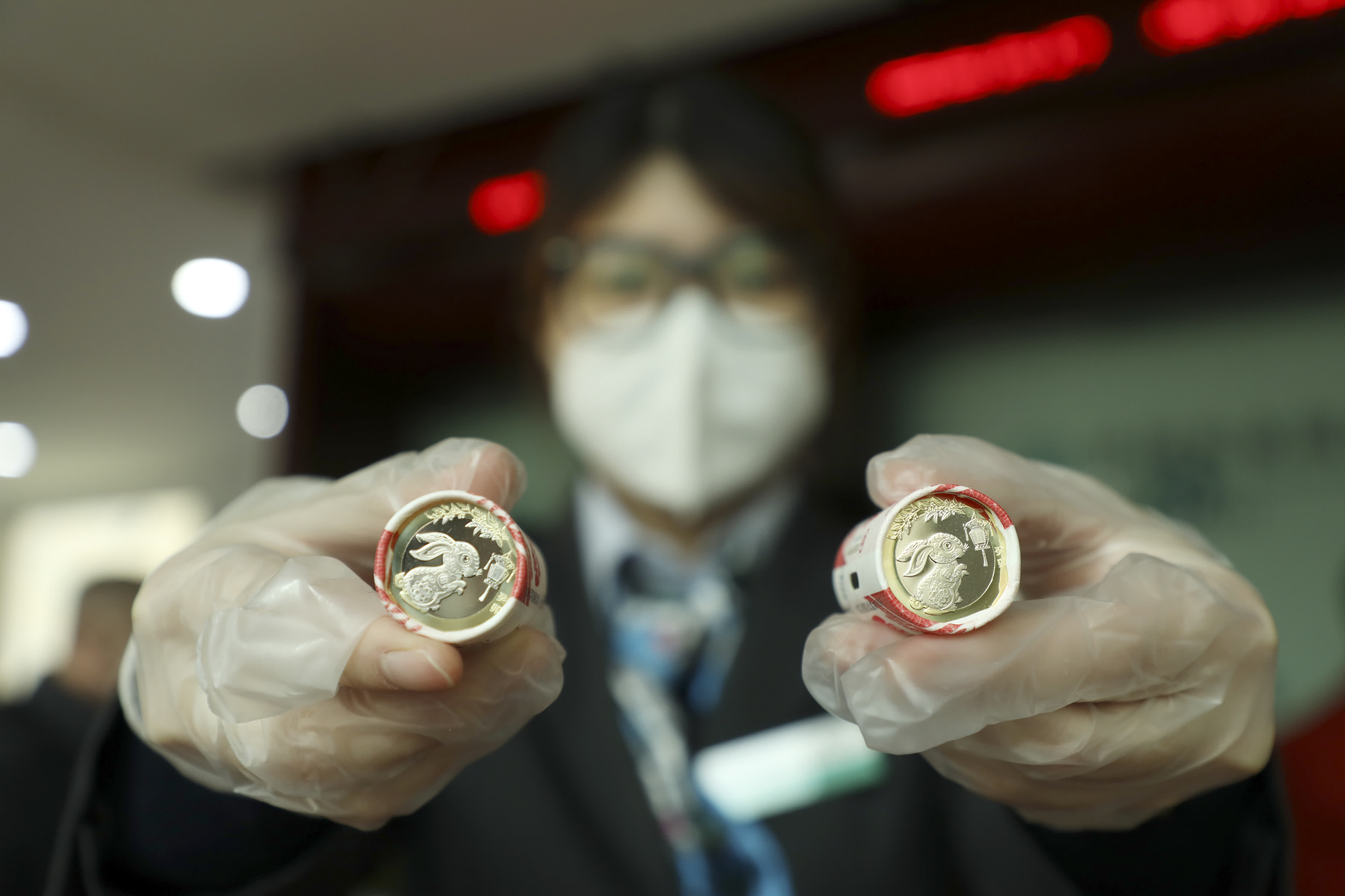 在山東省濱州市博興縣的一家銀行，工作人員展示2023年賀歲雙色銅合金紀念幣。（新華社）