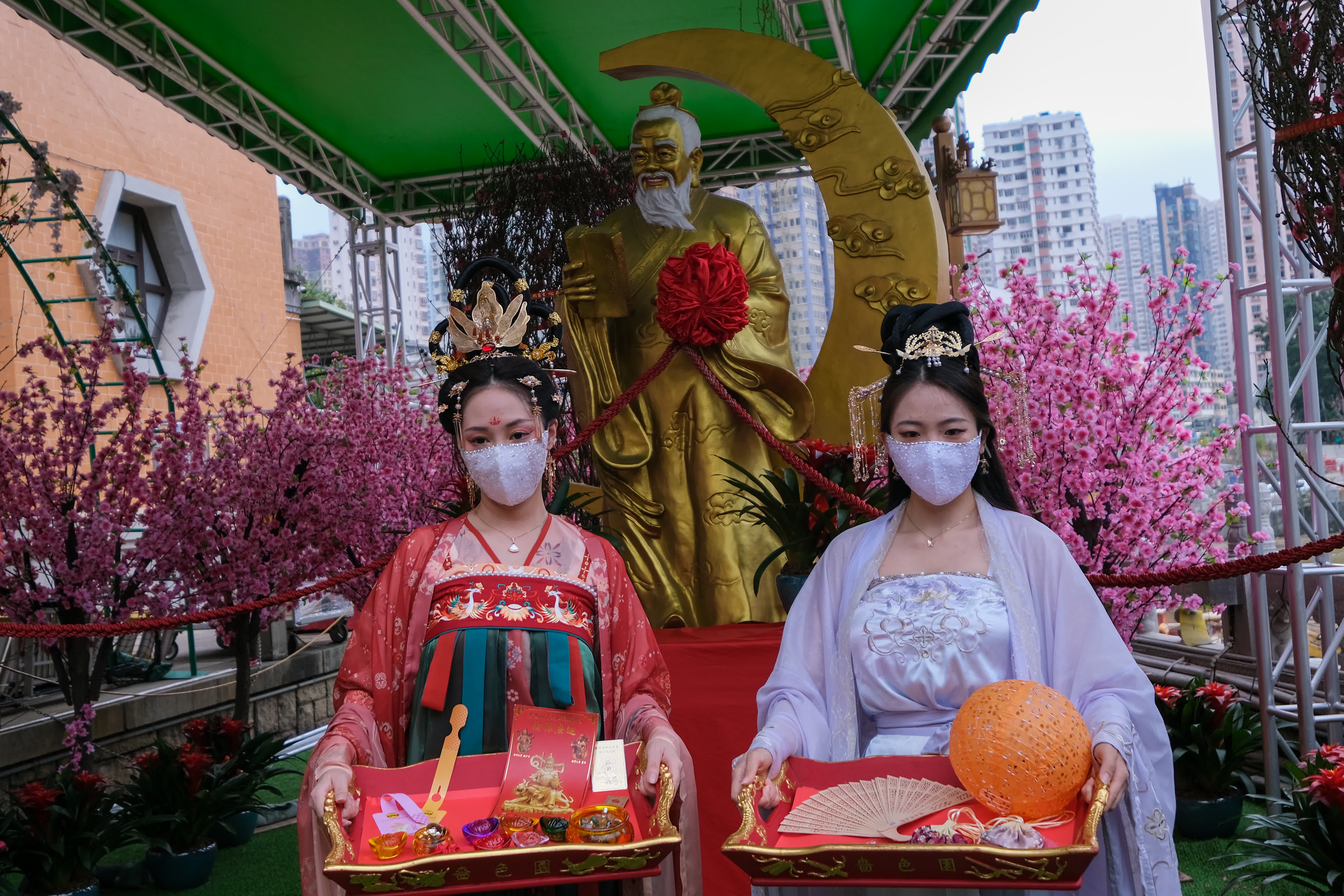 身穿漢服的女士展示黃大仙祠新春期間向善信派發的福物。（中新社）