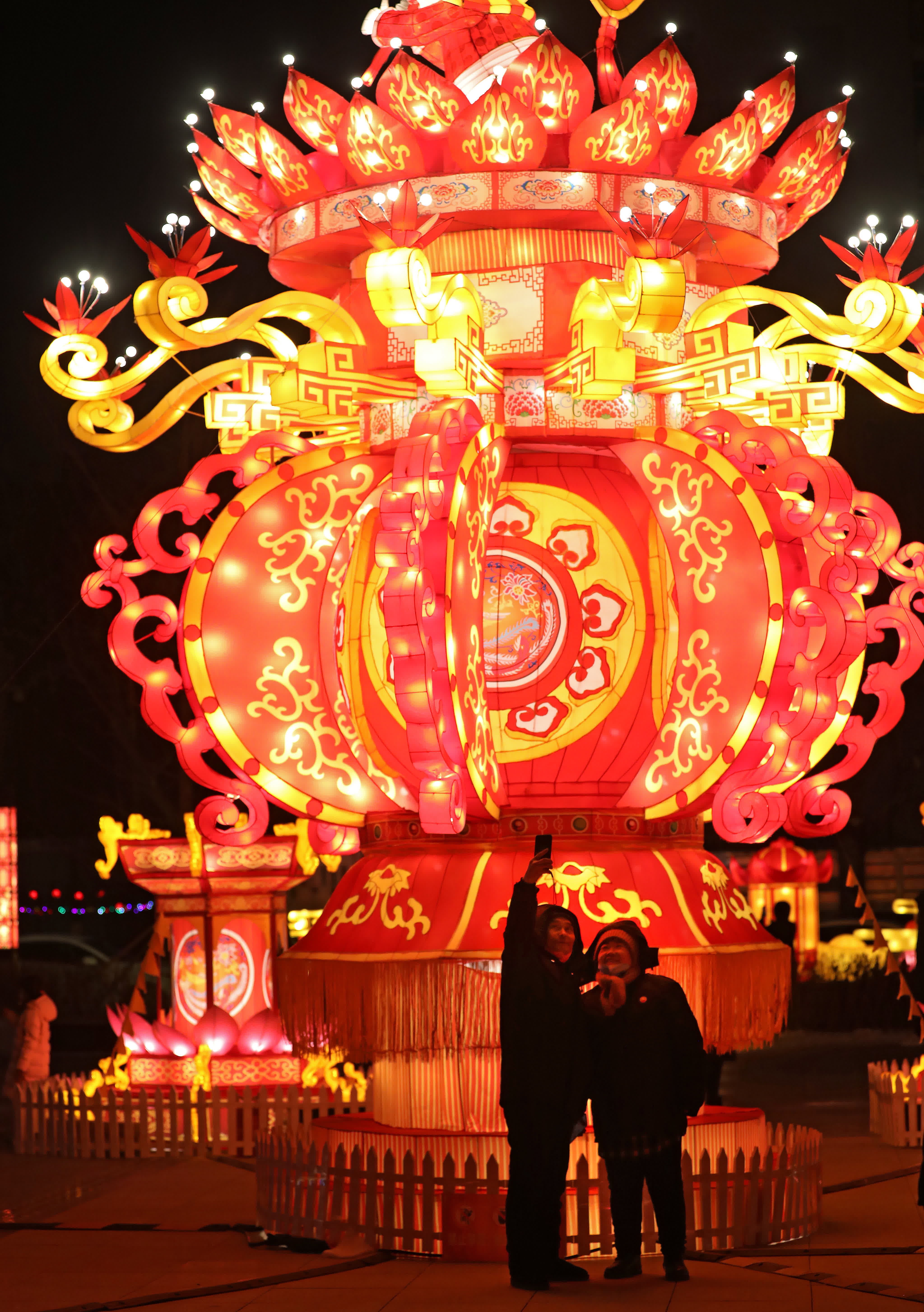 1月15日，兩位老人在瀋陽故宮門前廣場的花燈前拍照留影。（新華社）