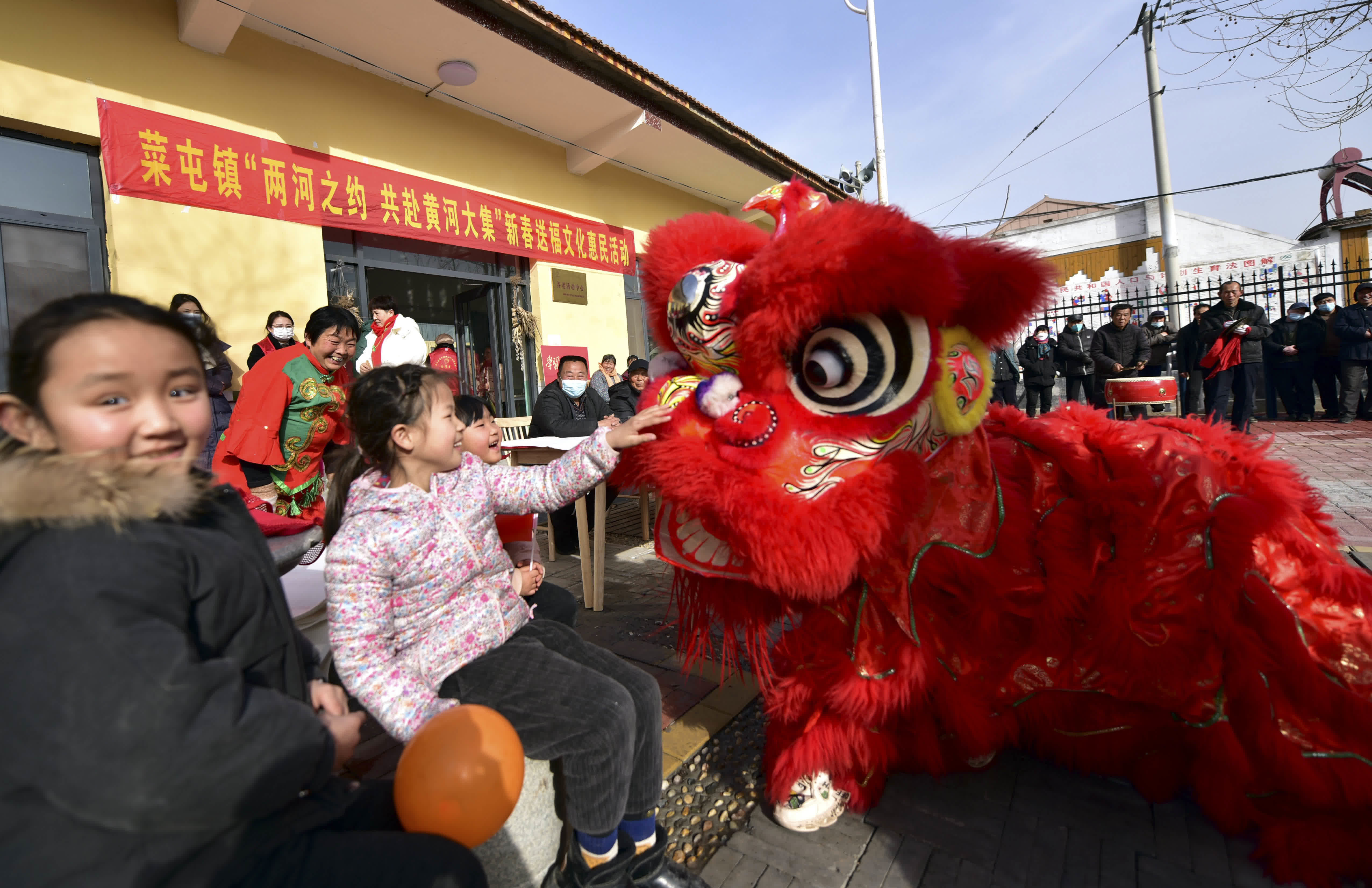  1月17日，在山東省聊城市茌平區菜屯鎮鳳凰新村，小朋友同舞獅表演進行互動嬉戲。