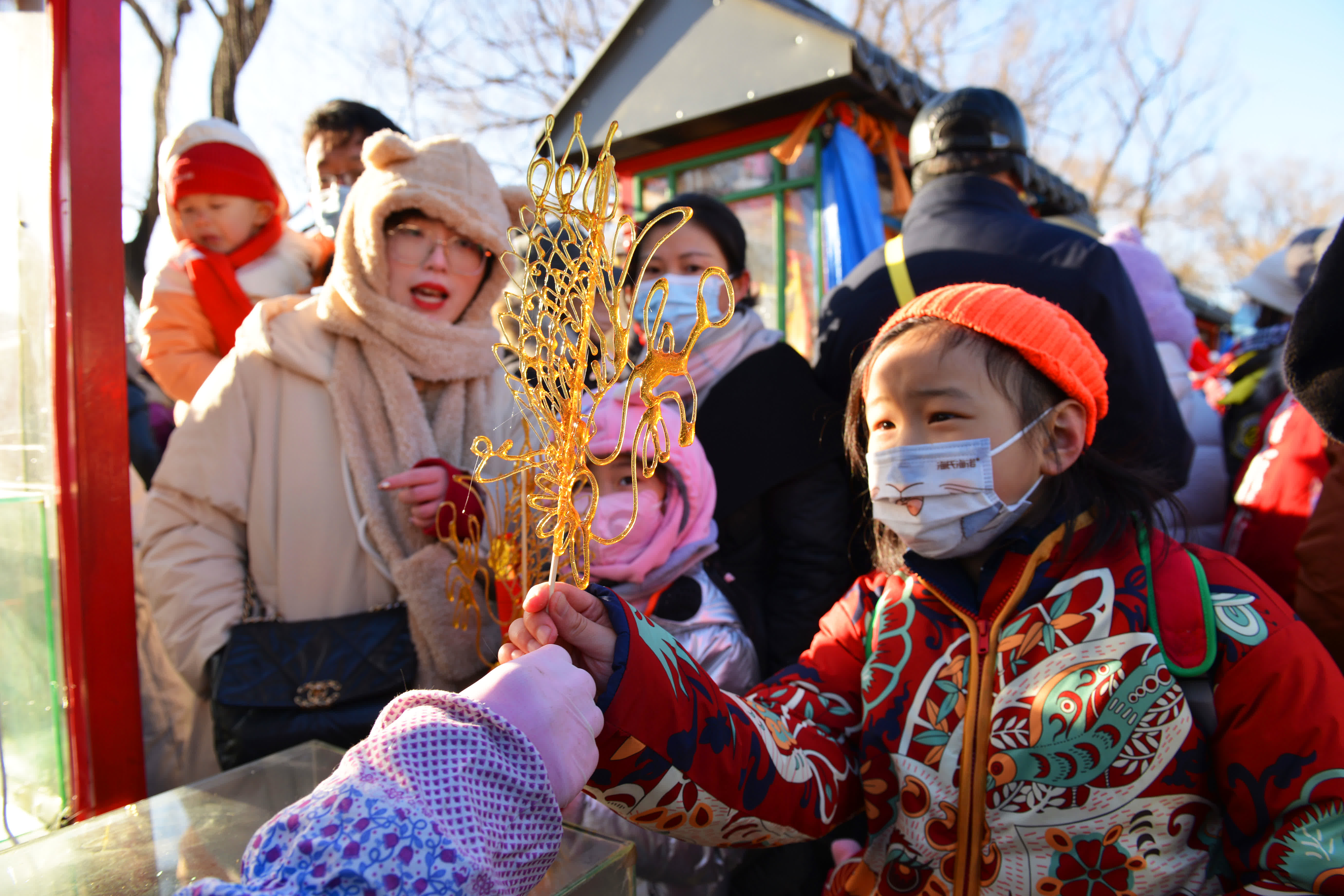 1月24日，小朋友在2023年圓明園新春遊園會上購買糖畫。（新華社）