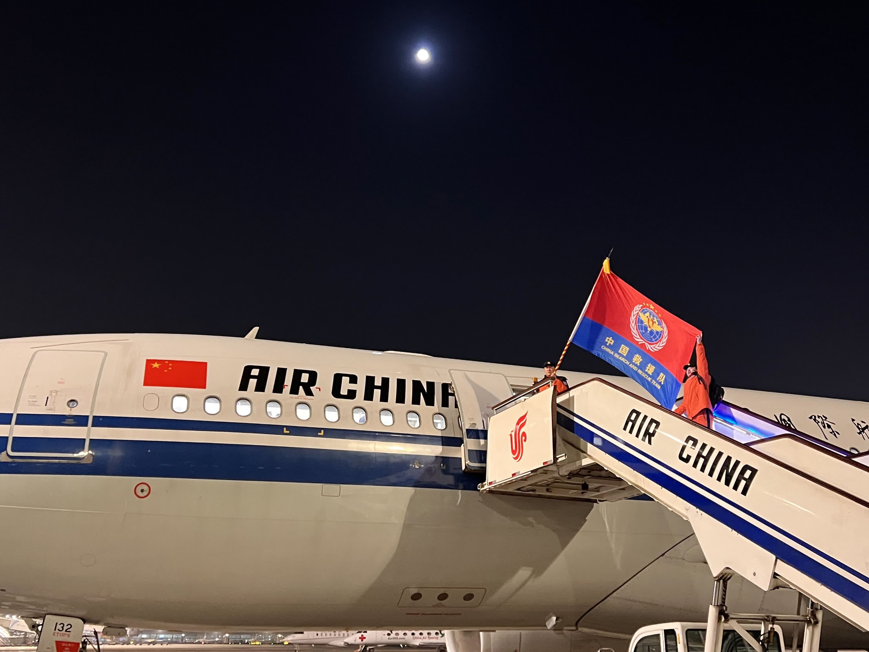 2月7日，中國救援隊隊員登上國航包機，從首都機場出發飛赴災區（手機拍攝）。（新華社）