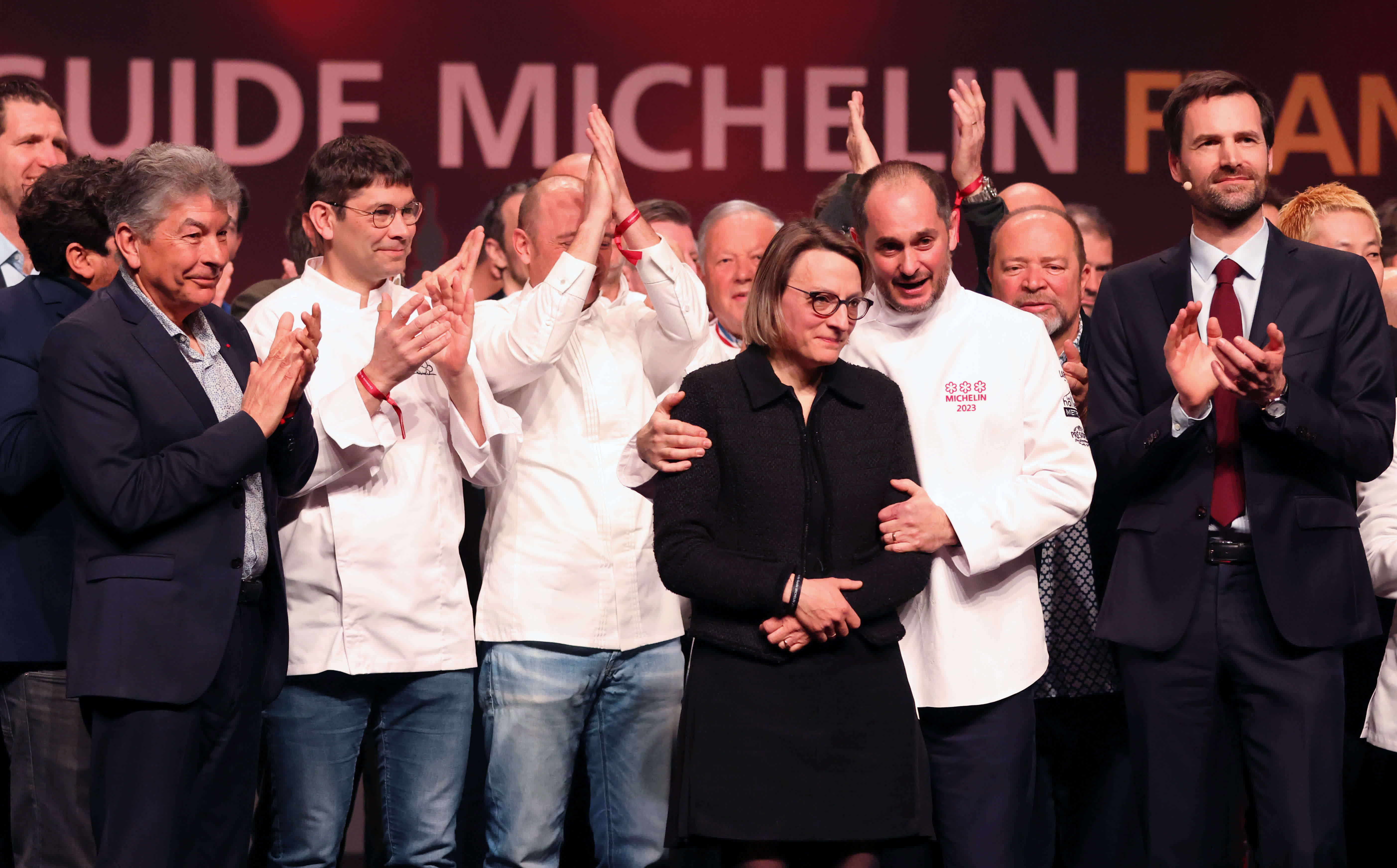 3月6日，在法國東部城市斯特拉斯堡舉辦的2023《米其林指南》法國版發布儀式上，獲頒米其林三星的法國廚師亞歷山大·庫永（前右二）與妻子慶祝。（新華社）