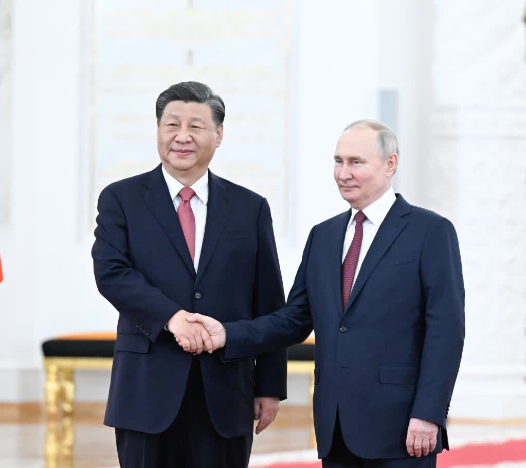 兩國元首緊緊握手，合影留念。軍樂團奏中俄兩國國歌。（新華社）