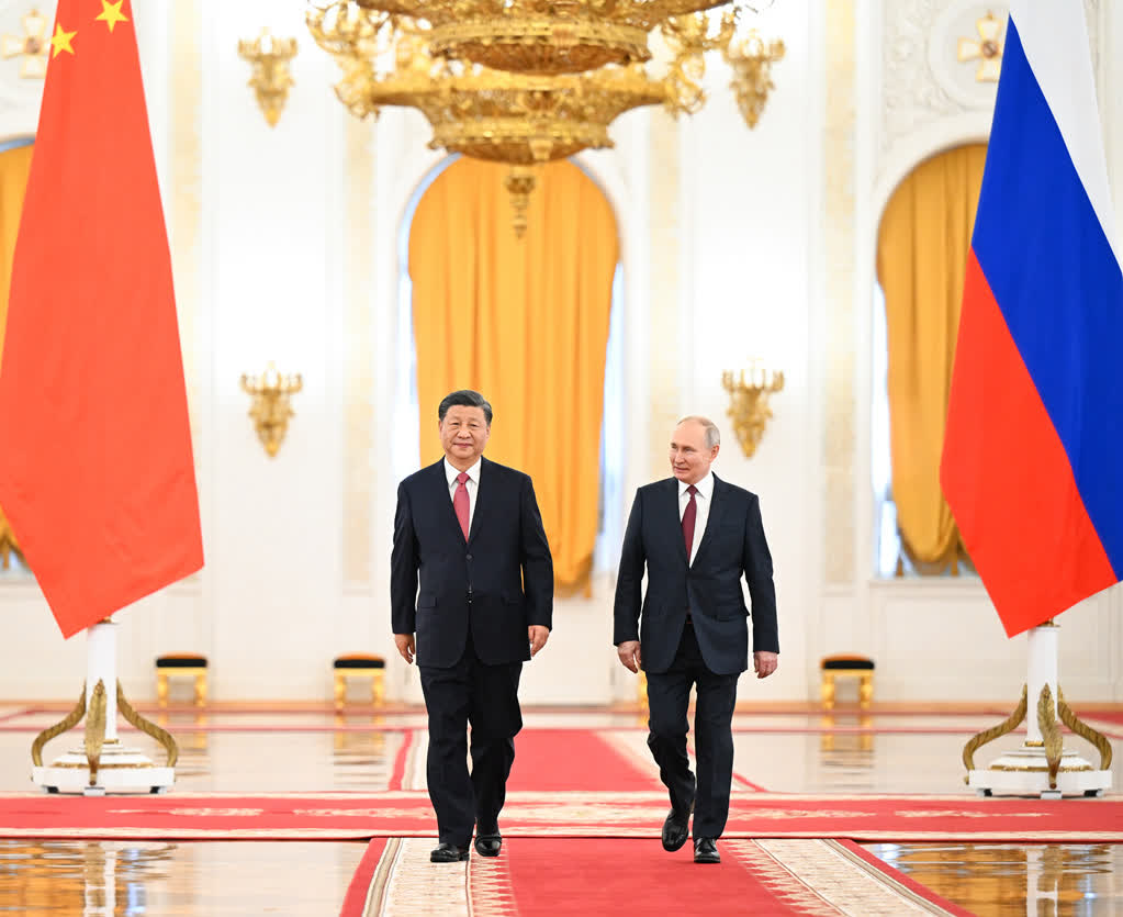 在雄壯激昂的迎賓曲中，習近平主席和普京總統分別從喬治大廳兩側沿紅地毯闊步走入大廳中央。（新華社）