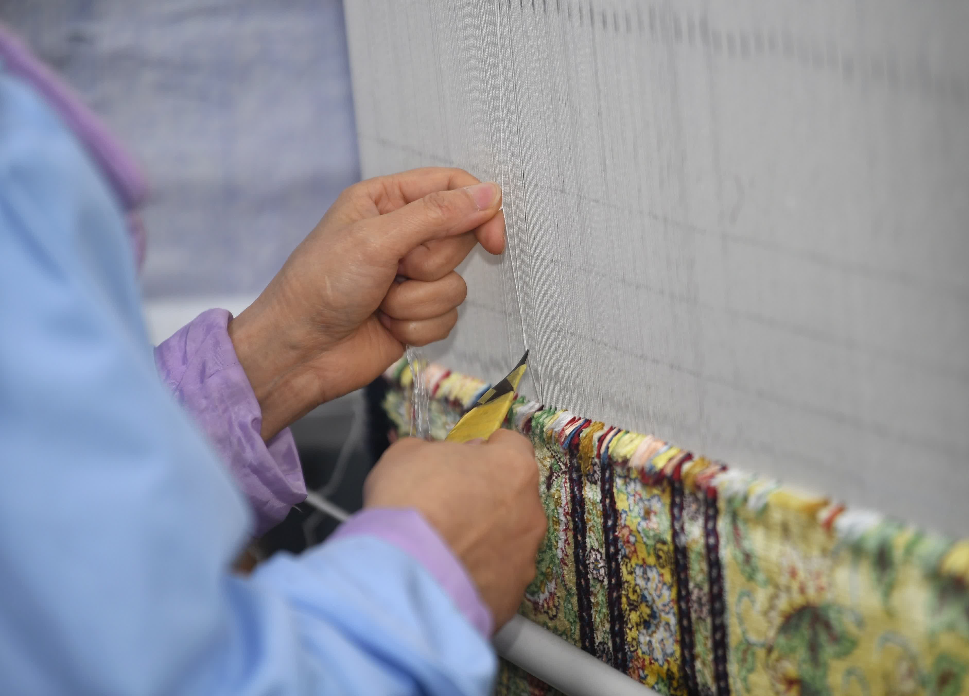 3月21日，四川閬中一家企業工人在編織絲毯。（新華社）