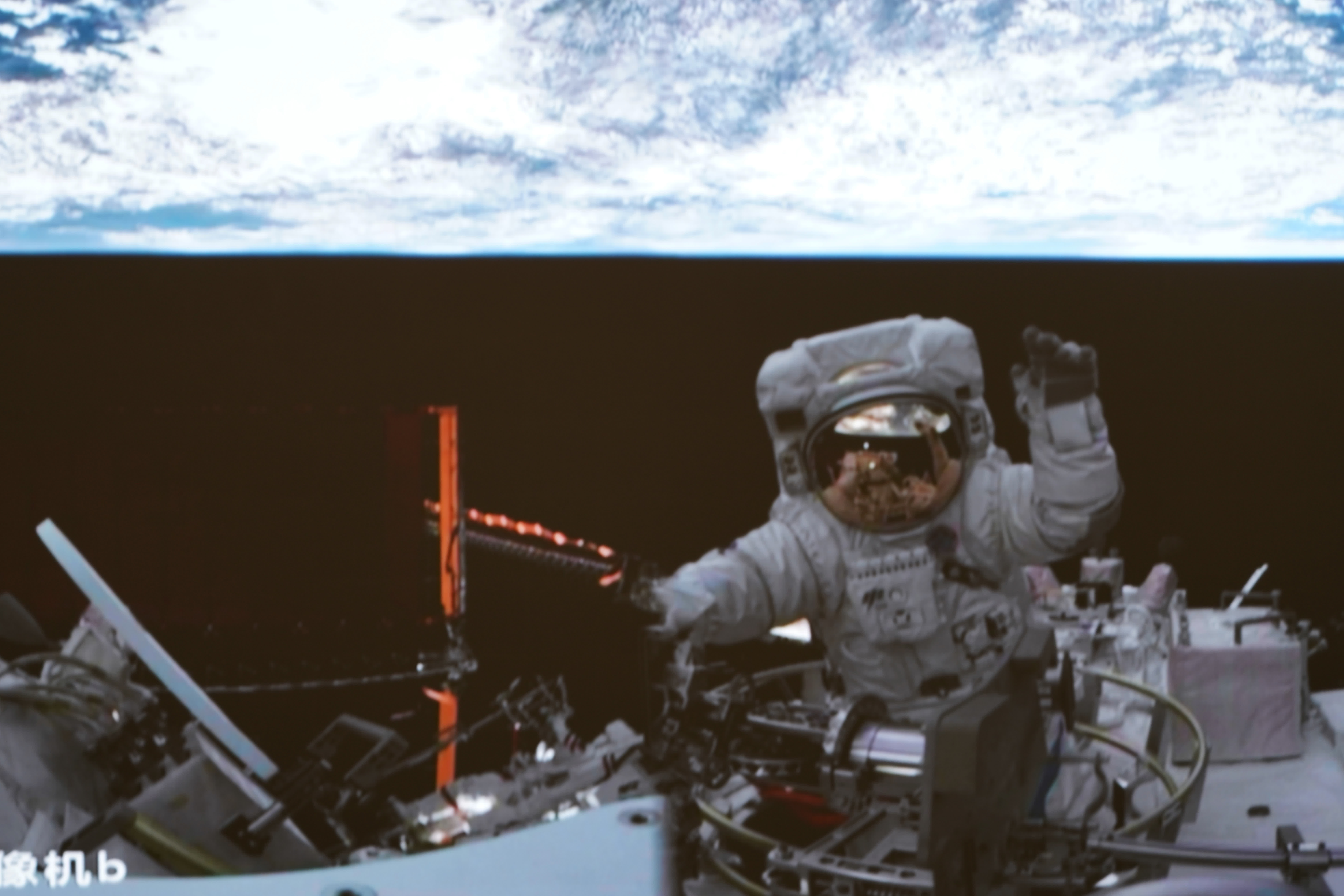 4月15日在北京航天飛行控制中心拍攝的神舟十五號航天員張陸結束出艙任務返回問天實驗艙時揮手致意的畫面。（新華社）