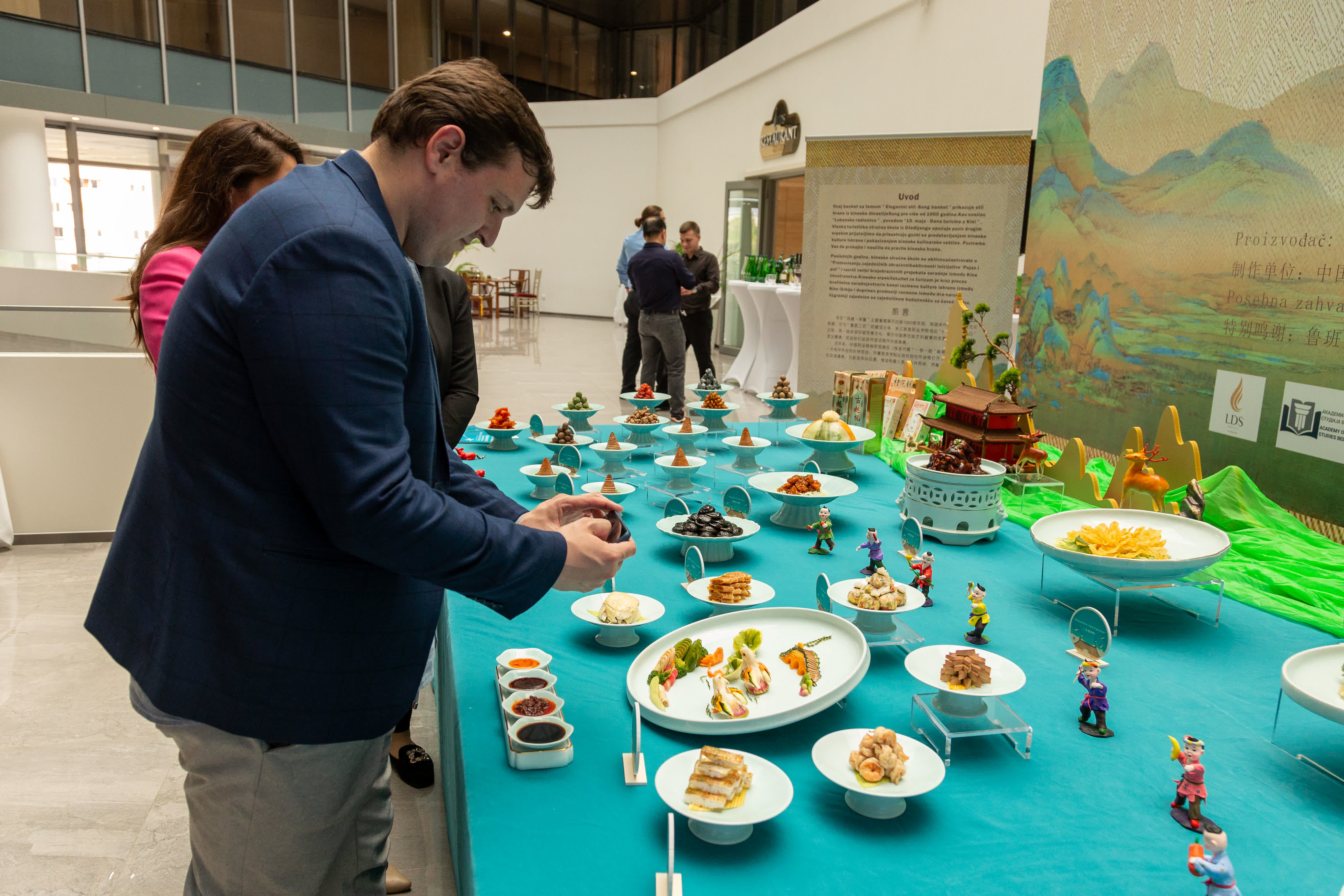 5月19日，人們在塞爾維亞首都貝爾格萊德舉行的塞爾維亞魯班工坊揭幕儀式暨「風雅·宋宴」美食文化展上欣賞中國美食。（新華社）