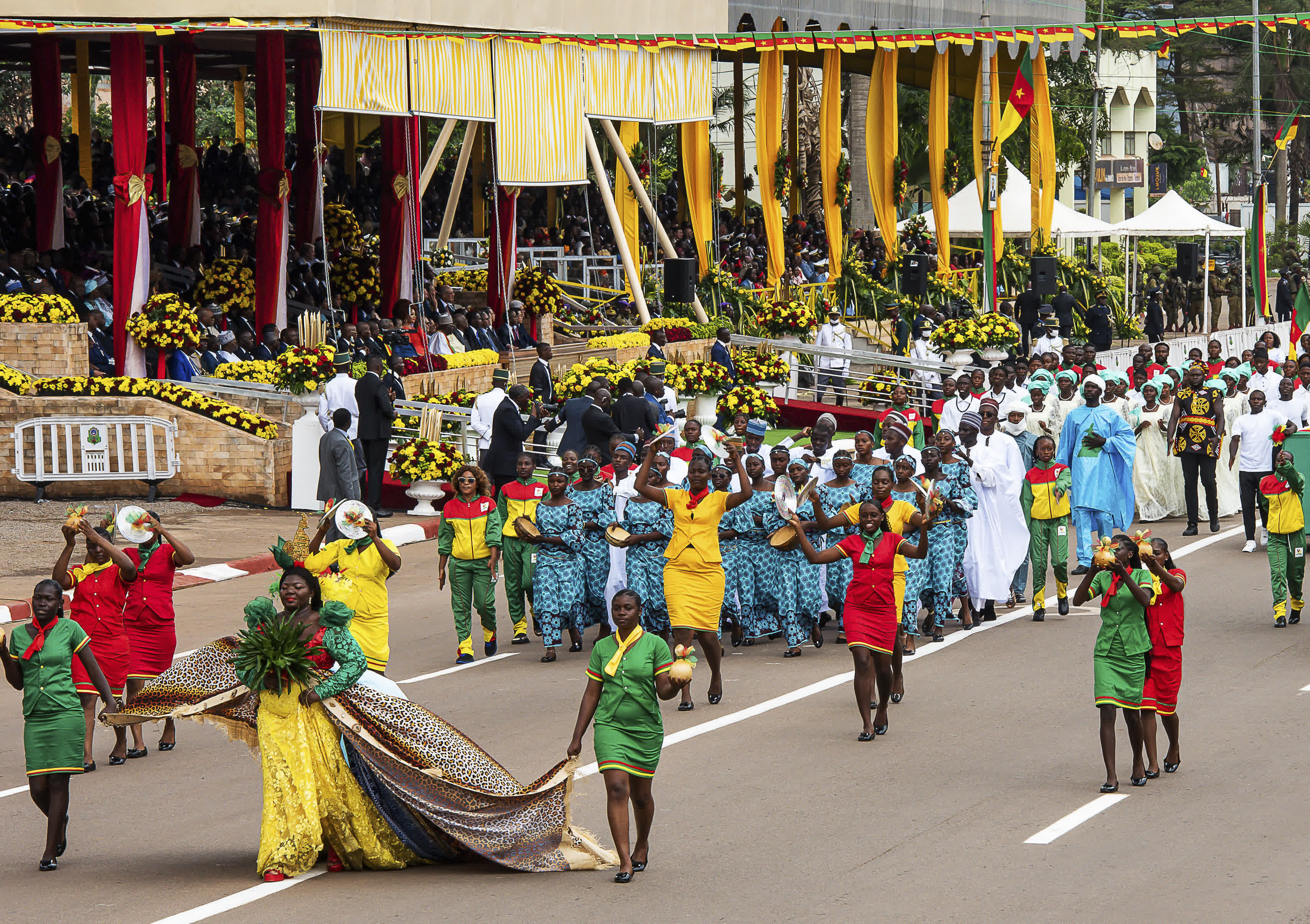 在喀麥隆首都雅溫得舉行的國慶慶祝活動上，身着民族服裝的民眾列隊行進。（新華社）