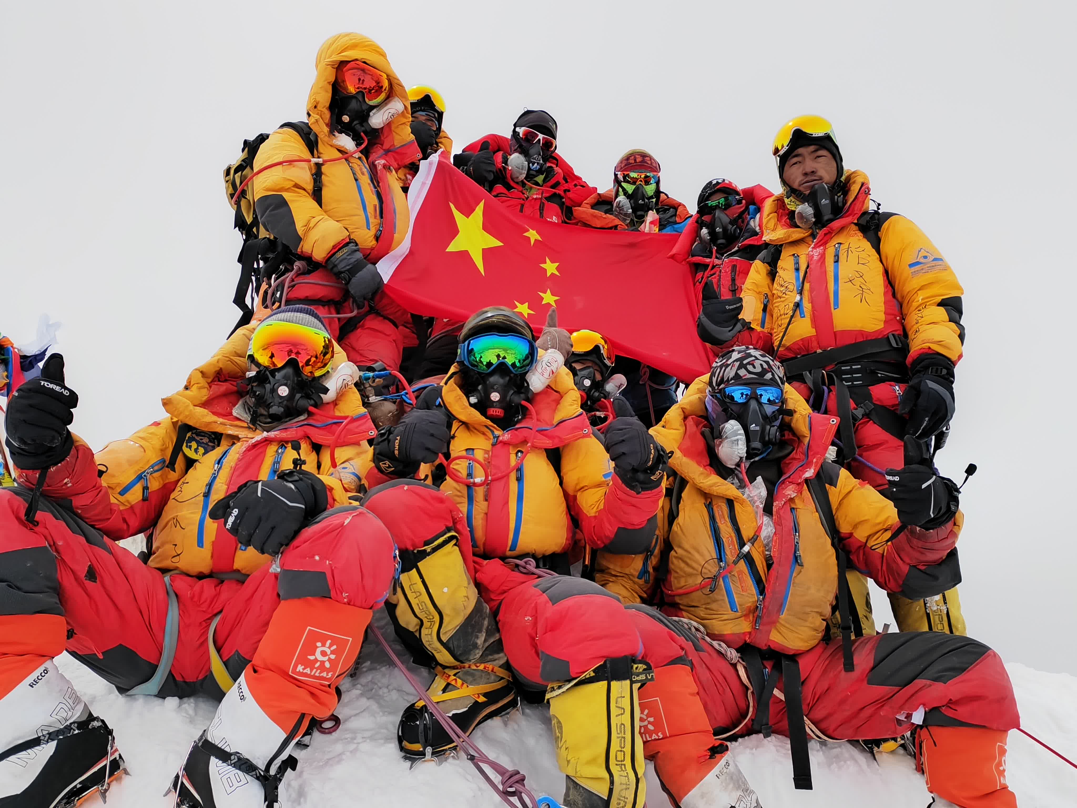 5月23日，科考登頂隊員在珠峰峰頂展示國旗。（新華社）