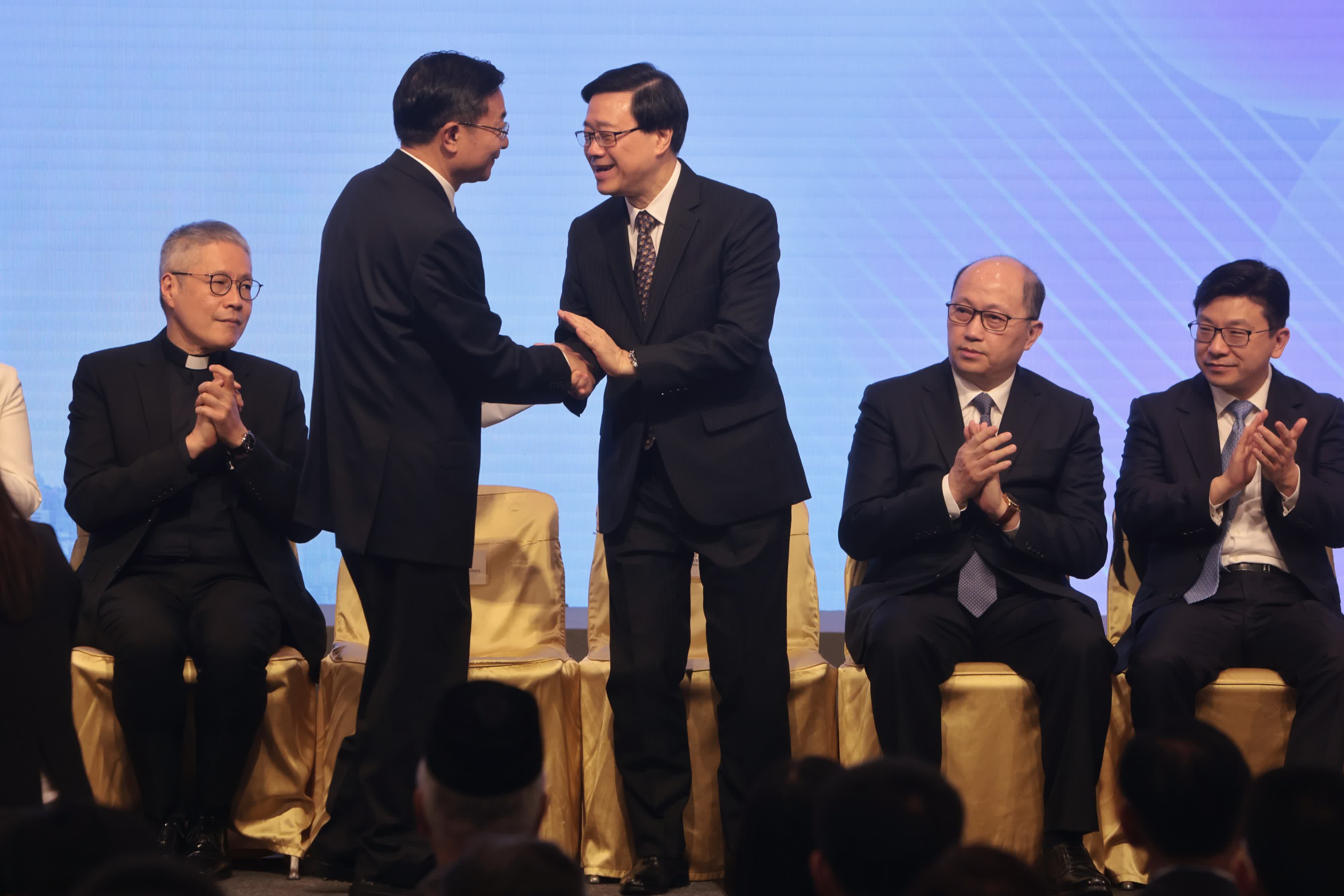 圖為香港特區行政長官李家超與中國國家民政部副部長柳拯在啓動儀式上握手交流。（香港中通社）