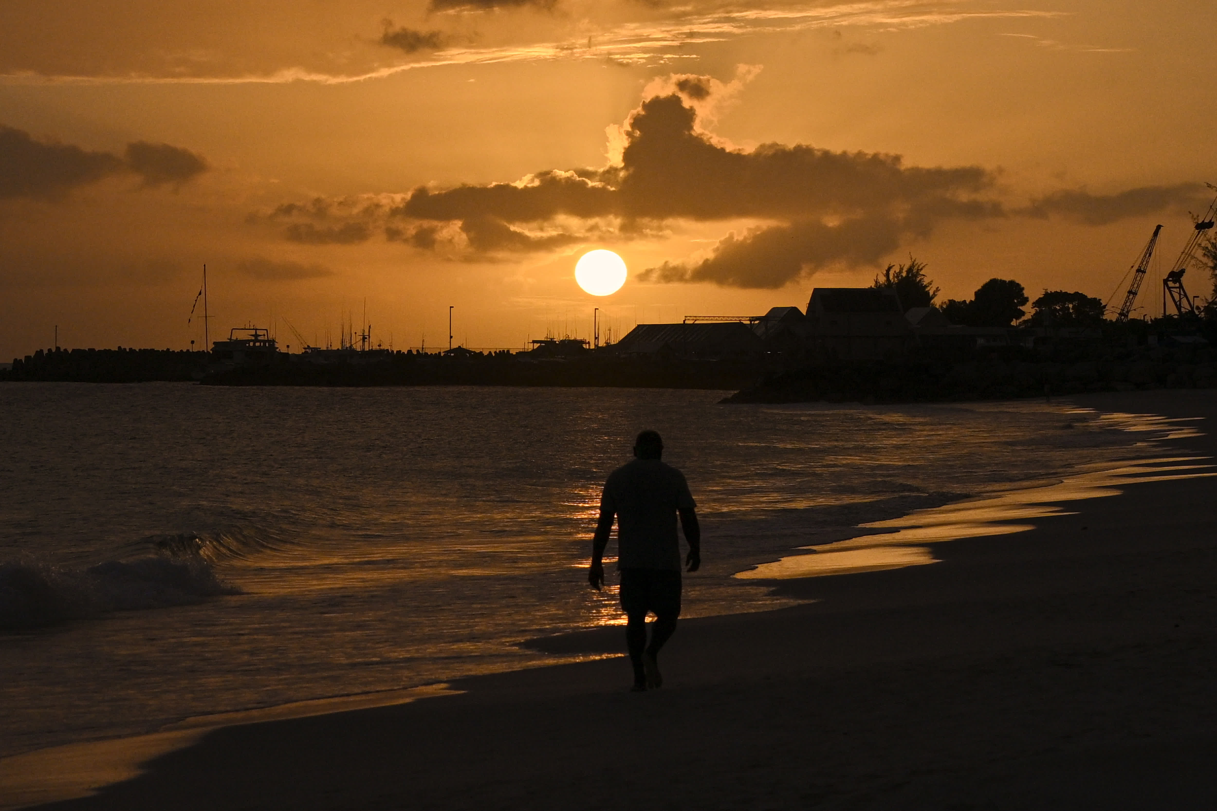 6月1日，一名男子走在巴巴多斯首都布里奇敦的一處海灘上。（新華社）