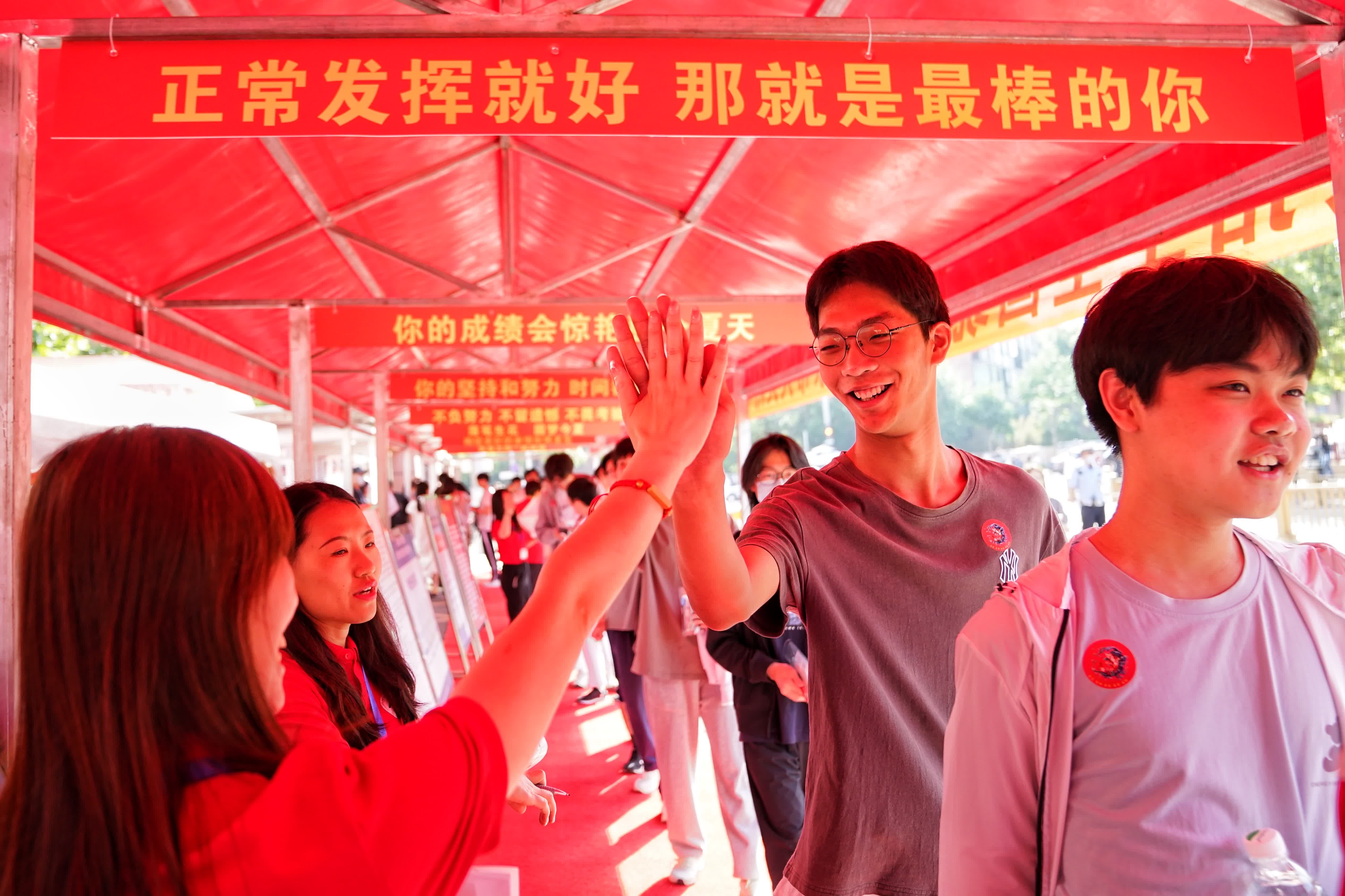 6月7日，在北京人大附中經開學校考點，送考老師與一位考生擊掌，為他加油鼓勁。