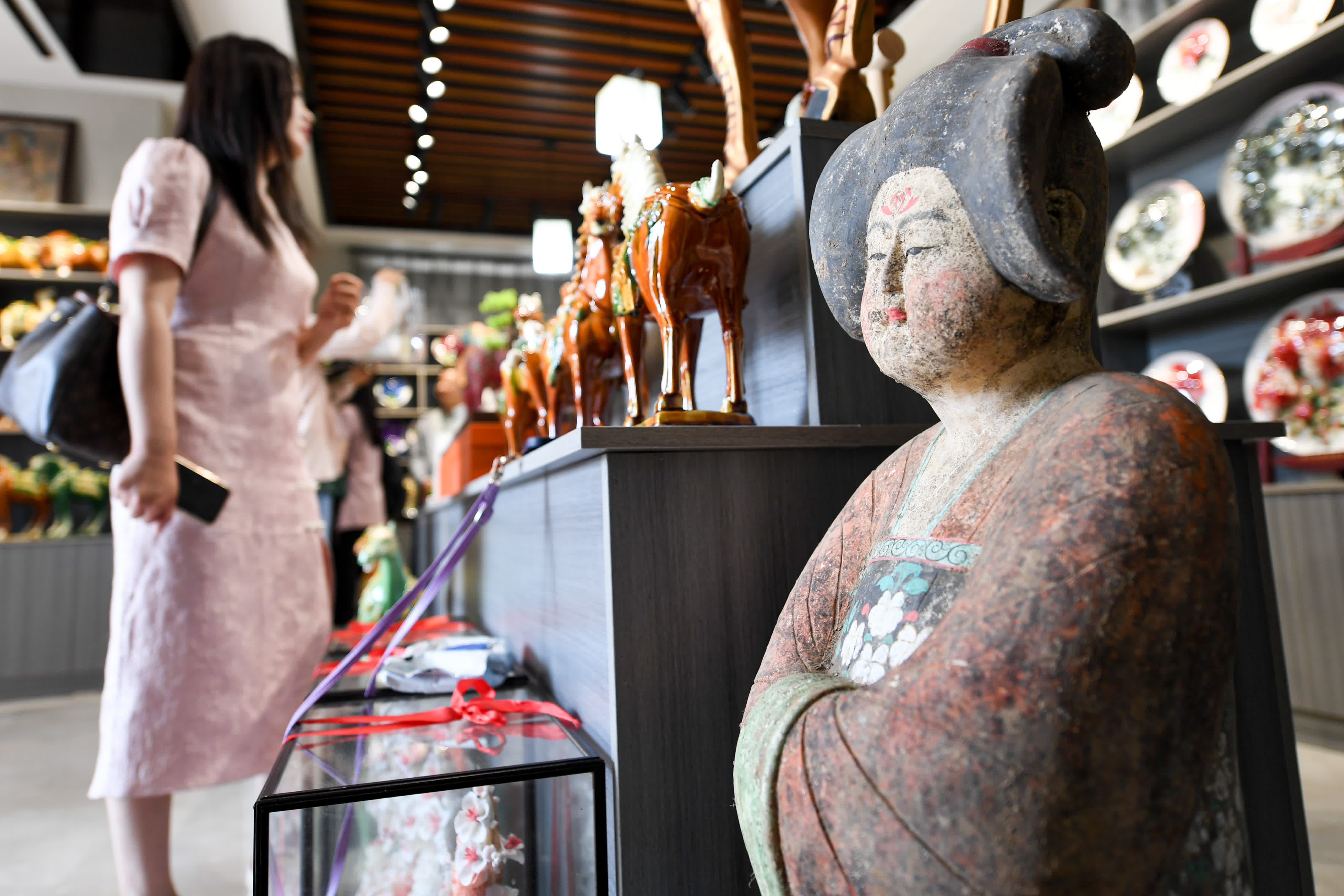 6月6日，遊客在南石山村的唐三彩商鋪內選購商品。（新華社）