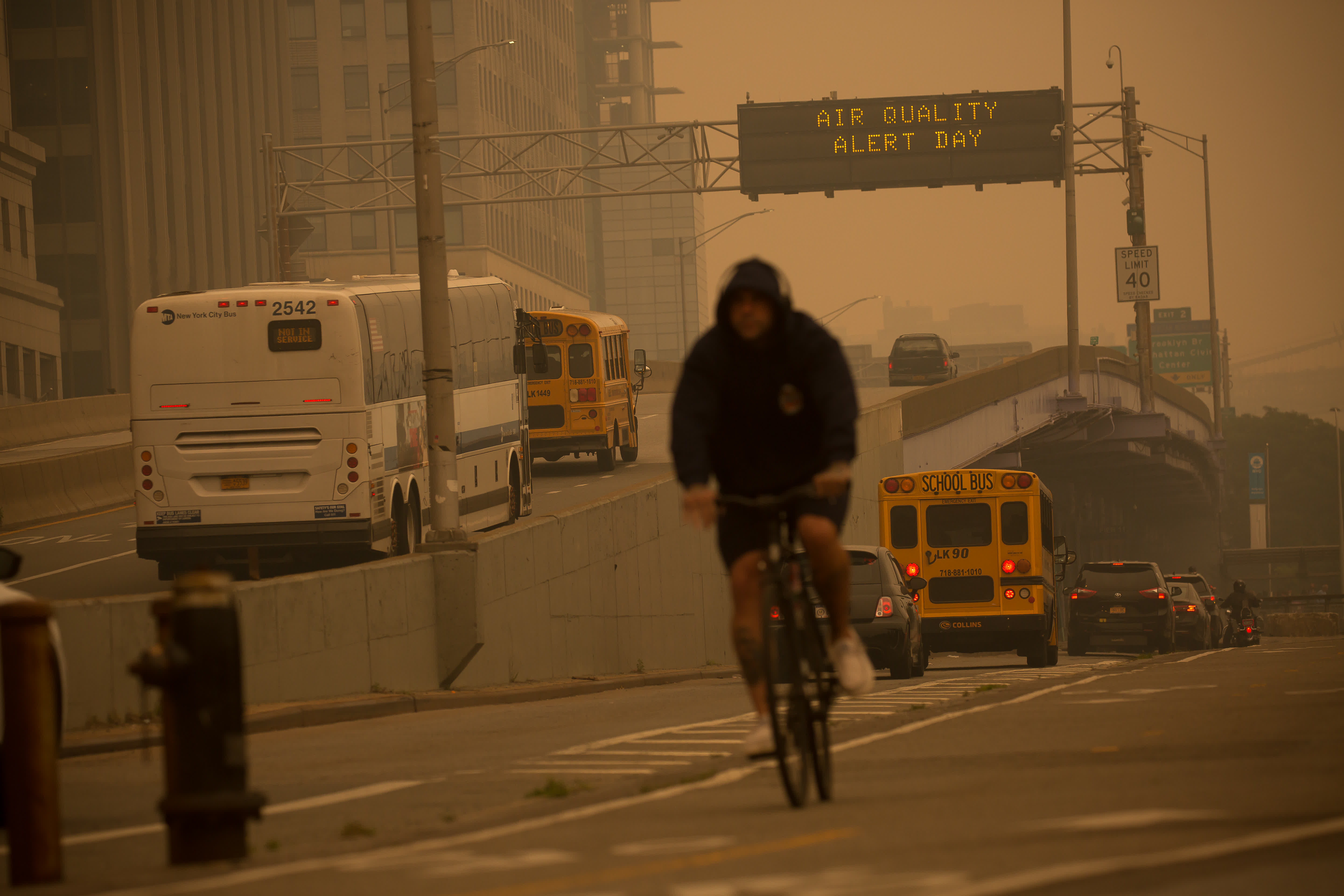 6月7日，一名市民騎自行車經過美國紐約一個空氣質量警報顯示牌。（新華社）