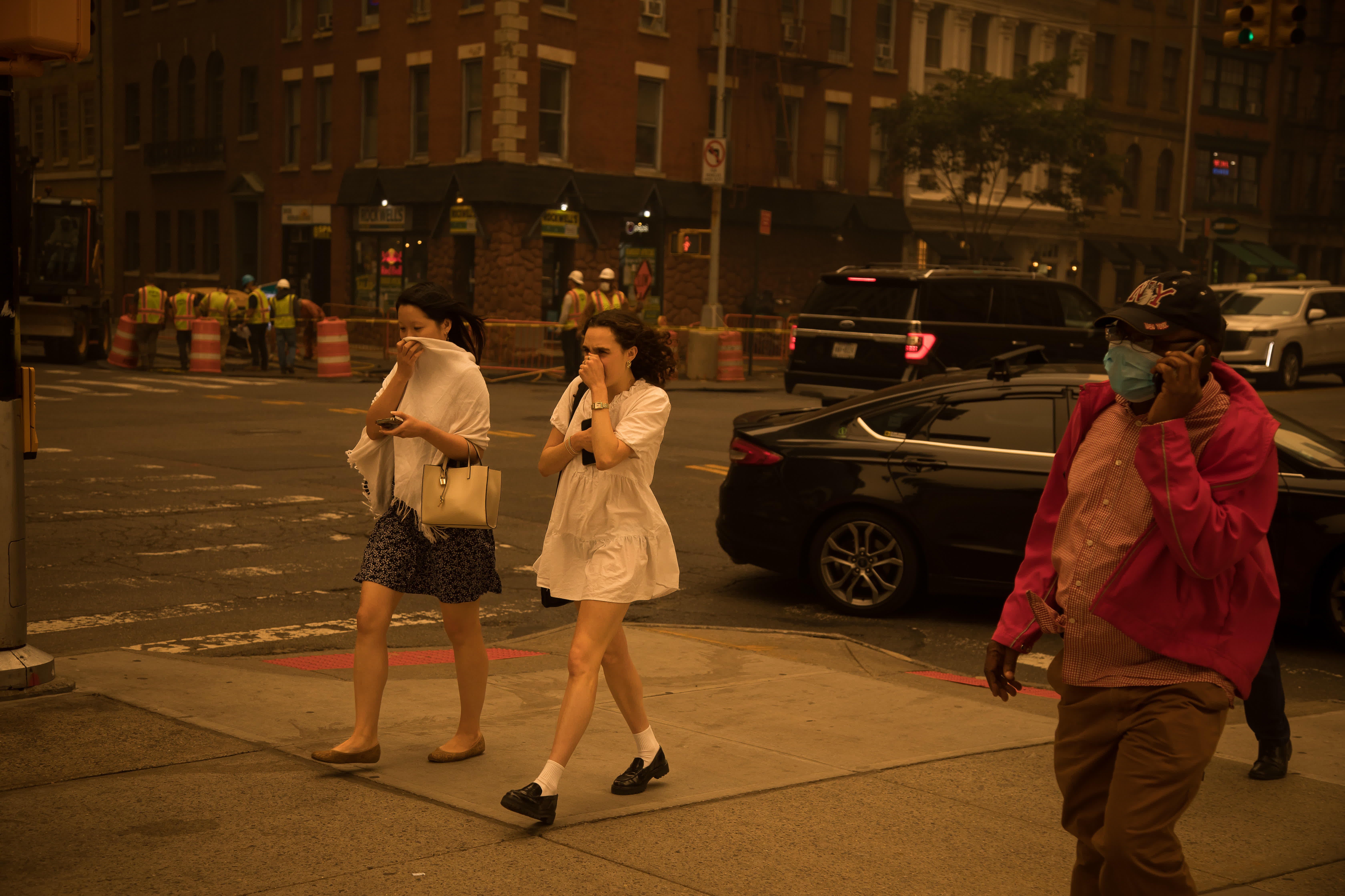 6月7日，行人以手掩住口鼻走在煙塵籠罩的美國紐約街頭。（新華社）