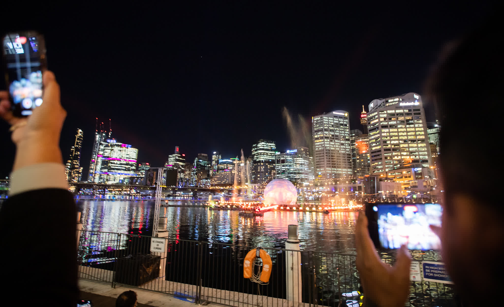 6月7日，在澳大利亞悉尼，遊客欣賞燈光秀並拍照。（新華社）