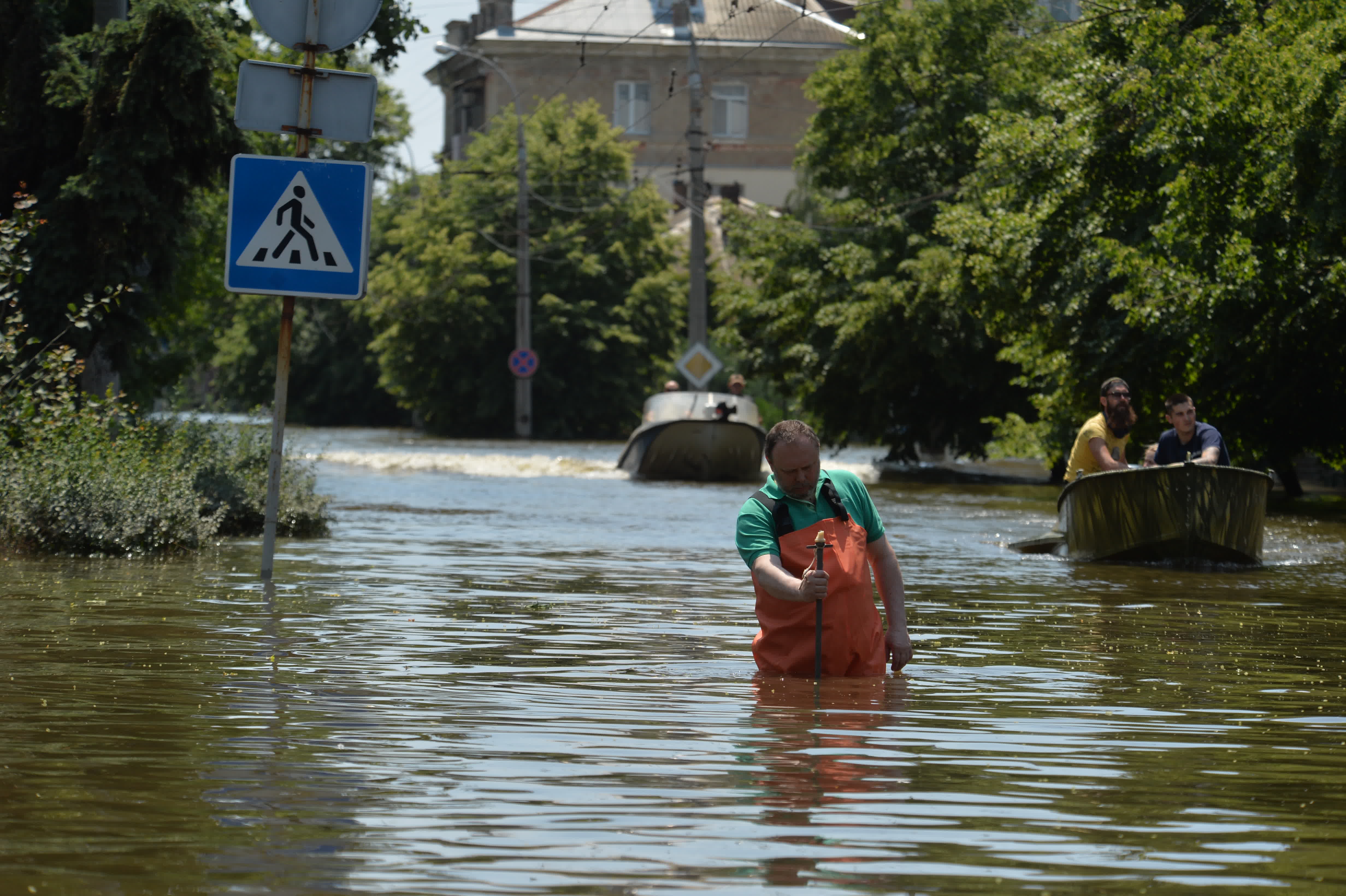 6月9日，一名水利工作人員在赫爾松市被洪水淹沒的街道測量水位。（新華社）