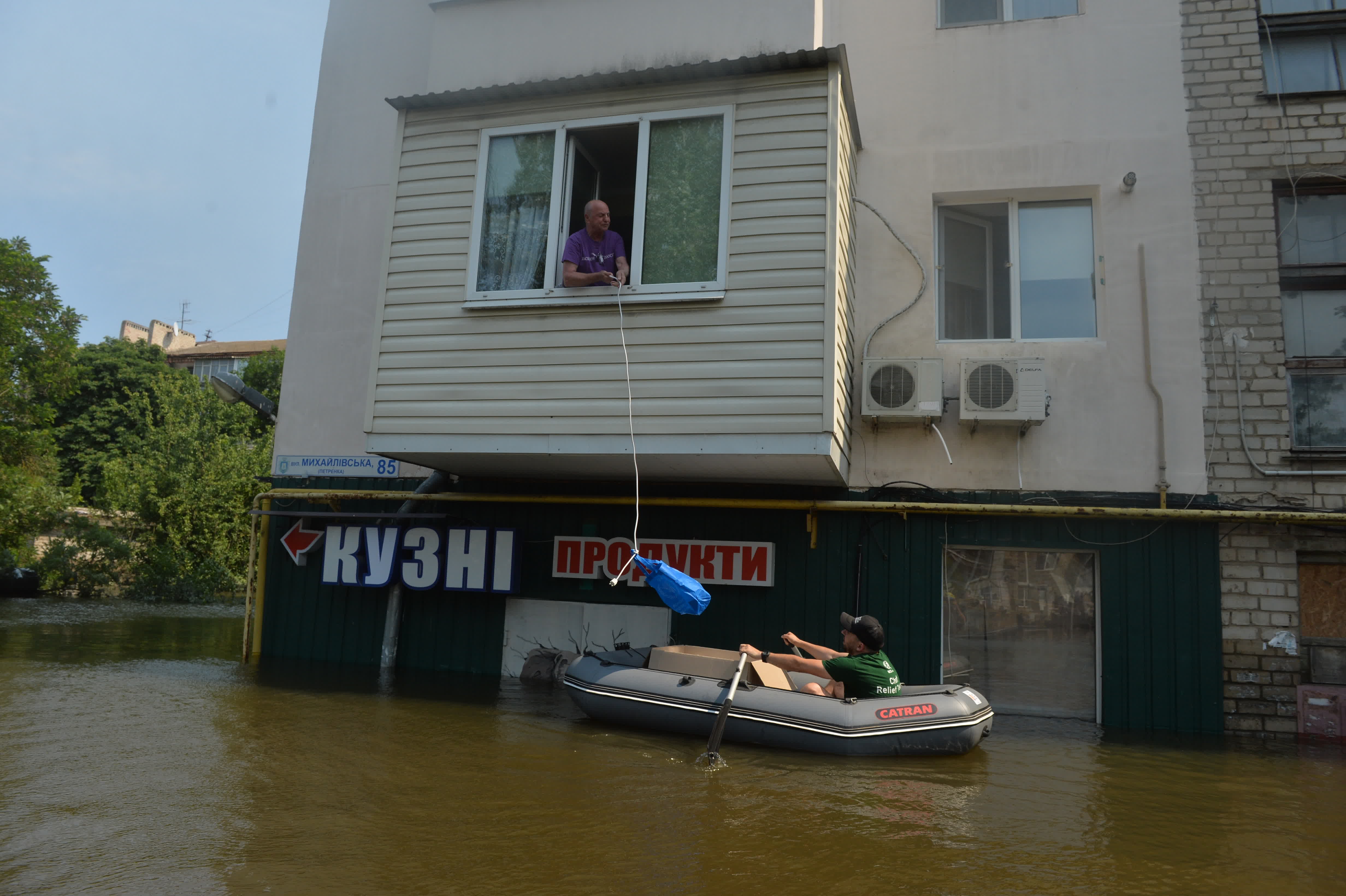 6月9日，志願者向被洪水圍困的赫爾松市民運送生活物資。（新華社）
