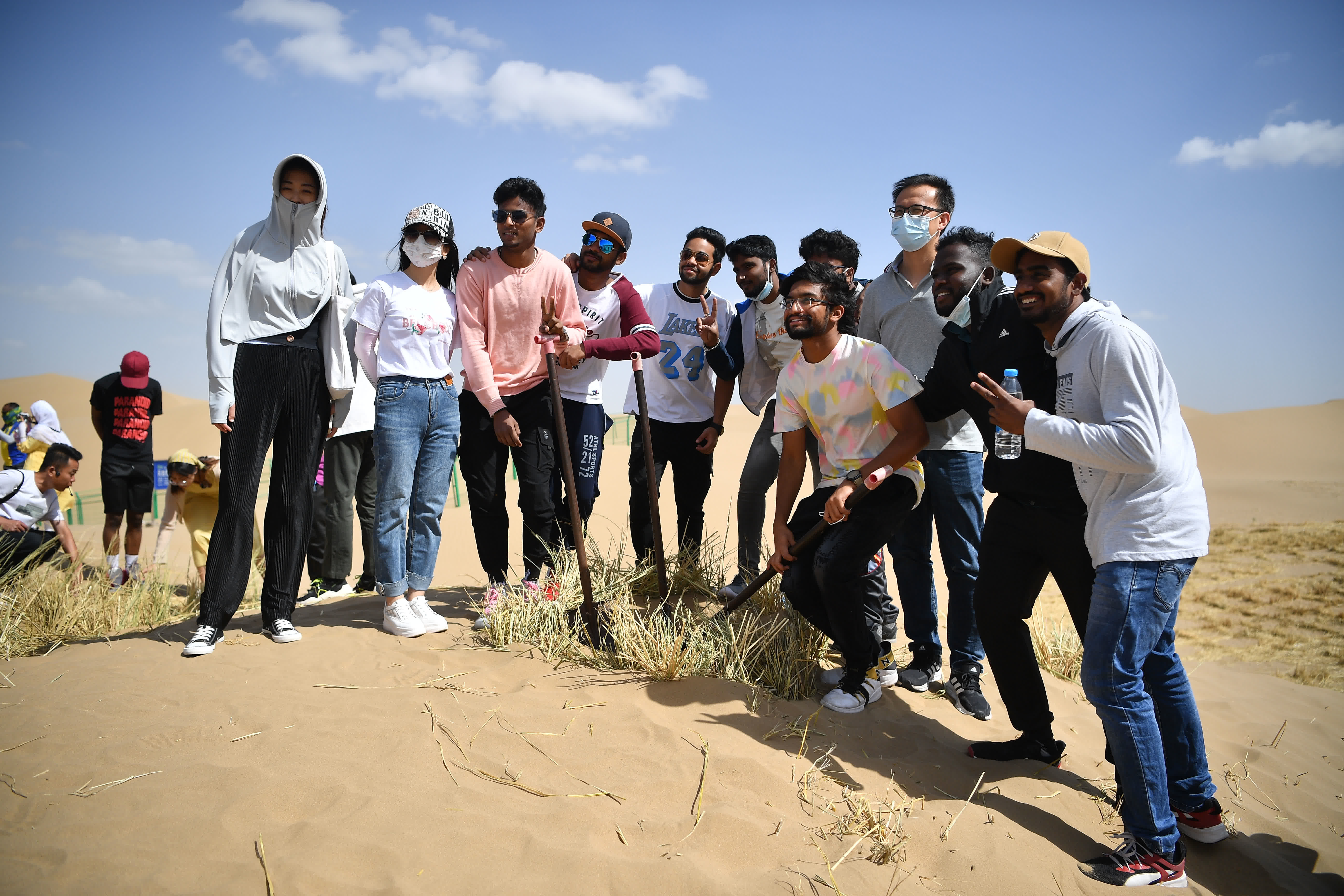 6月16日，留學生在寧夏靈武市白芨灘國家級自然保護區拍照合影。（新華社）