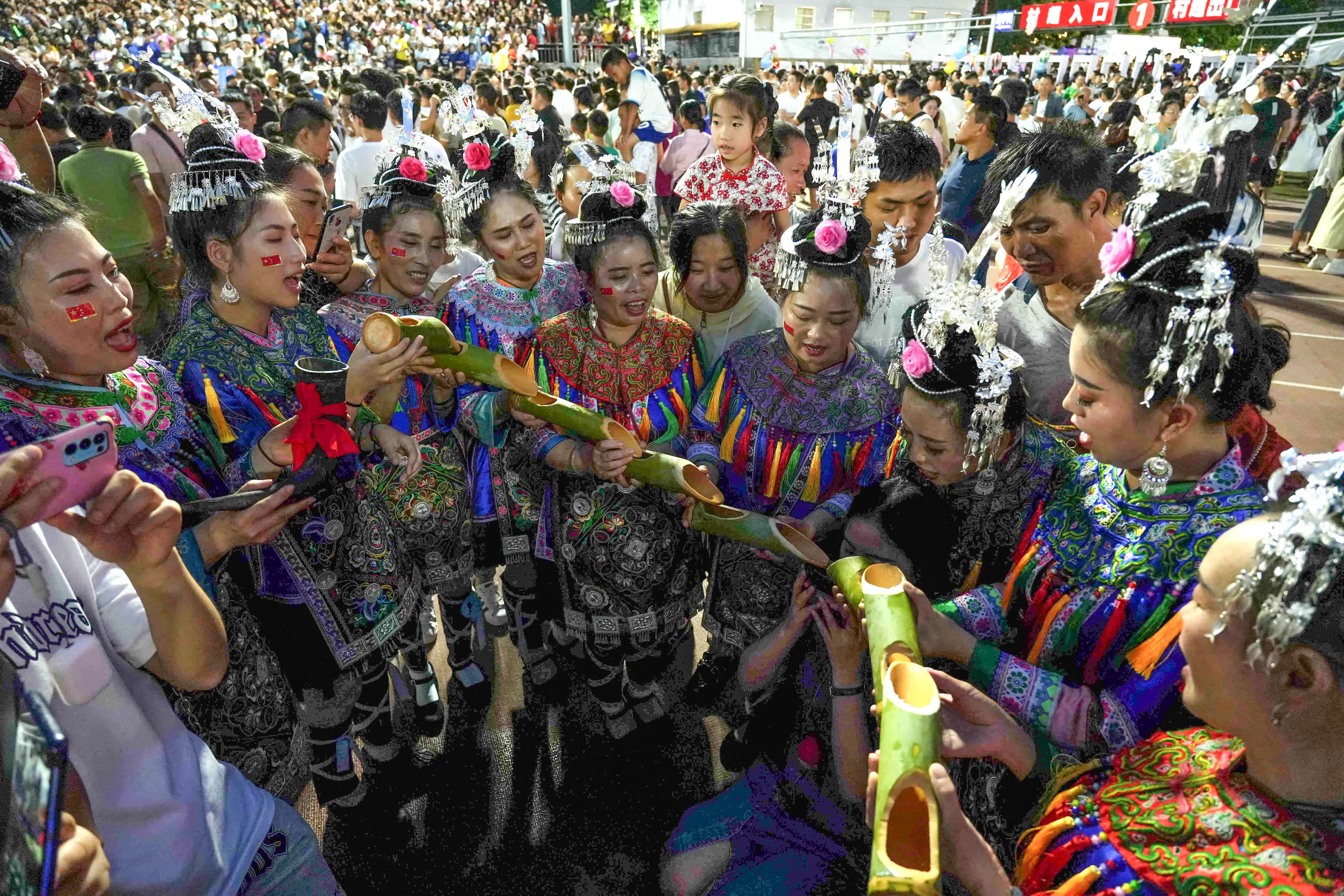 6月23日，遊客在體驗侗族「高山流水」敬酒風俗。（新華社）