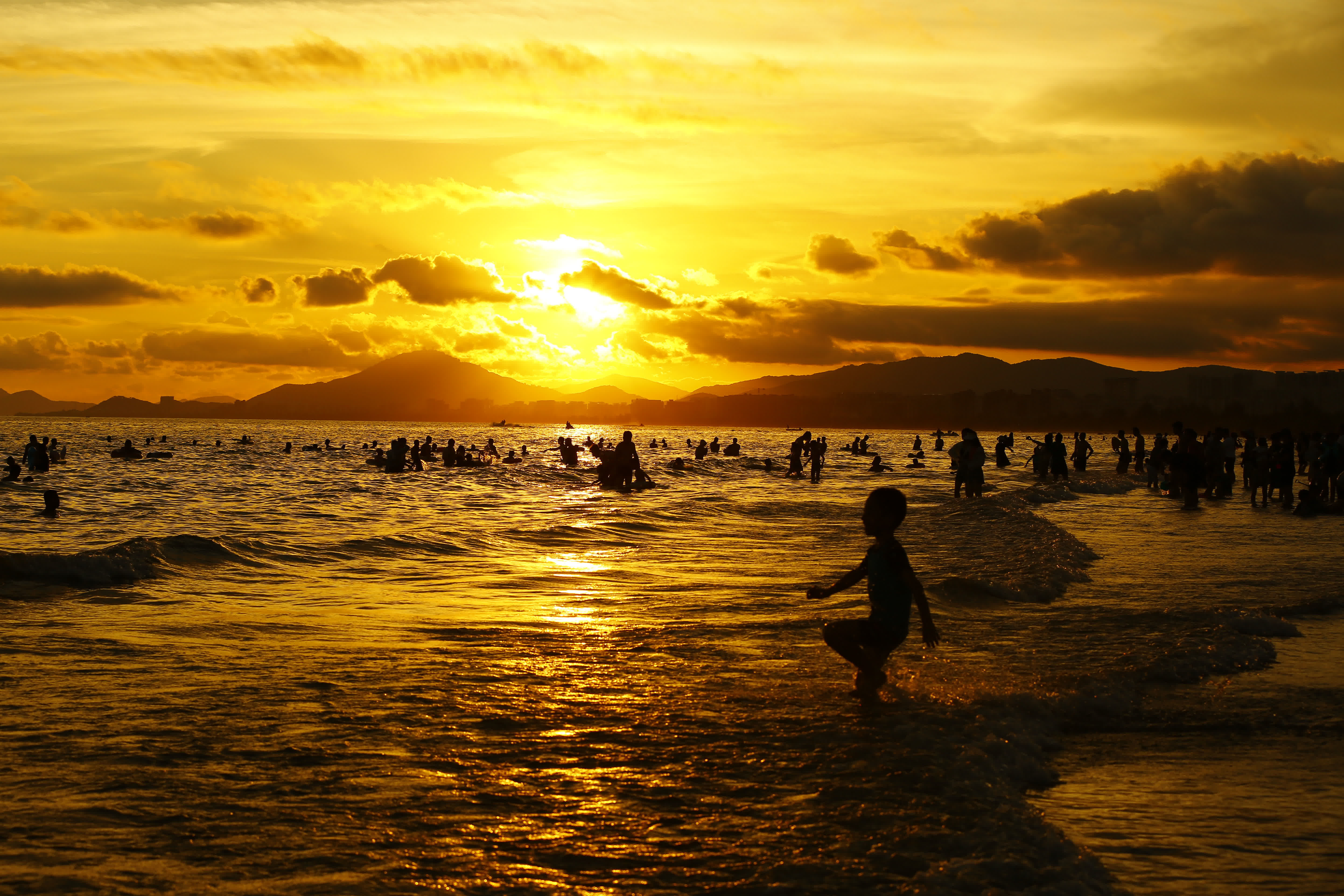 7月11日，家長帶着孩子在海南省三亞市三亞灣戲水消暑。（新華社）