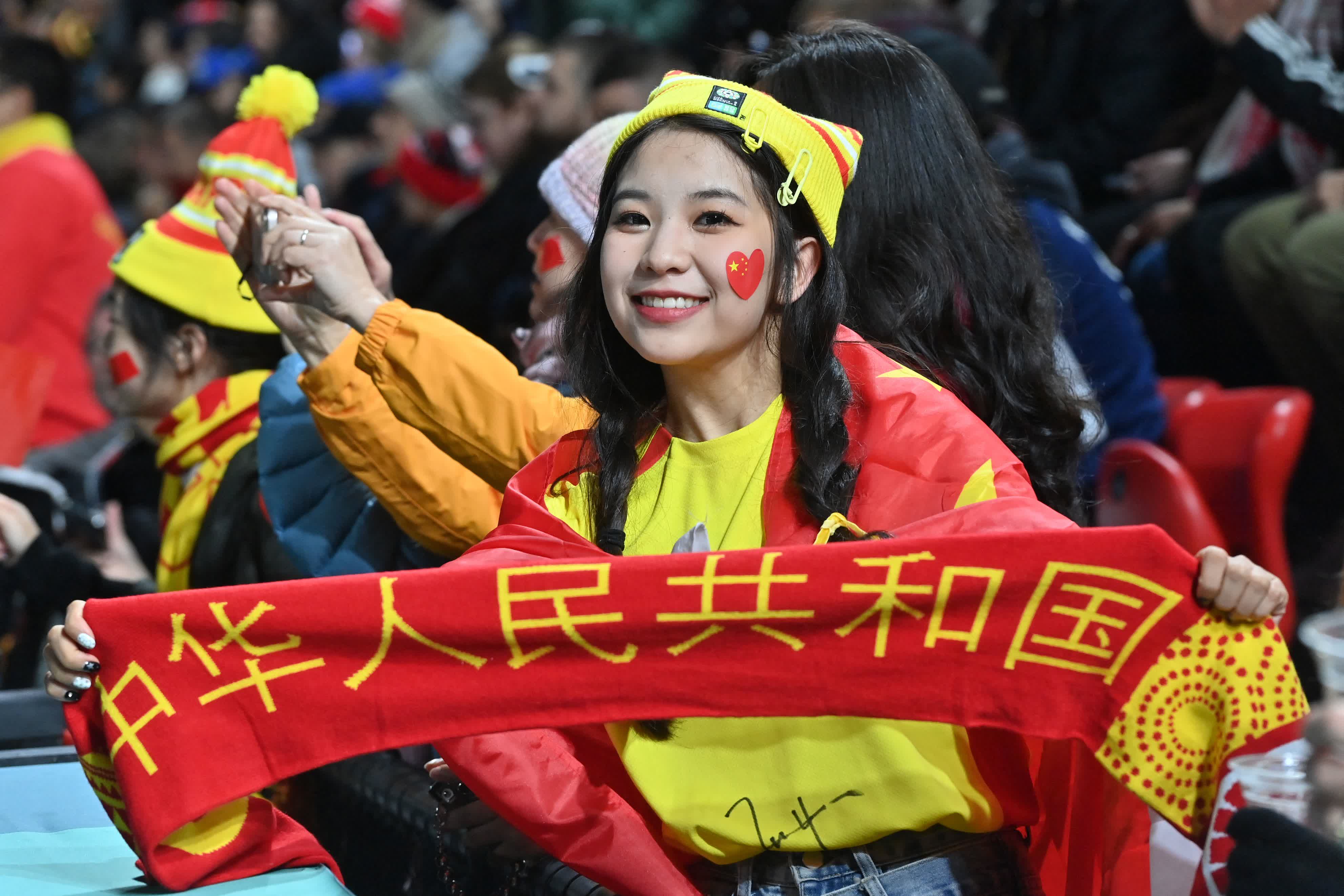 一位中國球迷舉橫幅在現場為中國隊加油。（法新社）