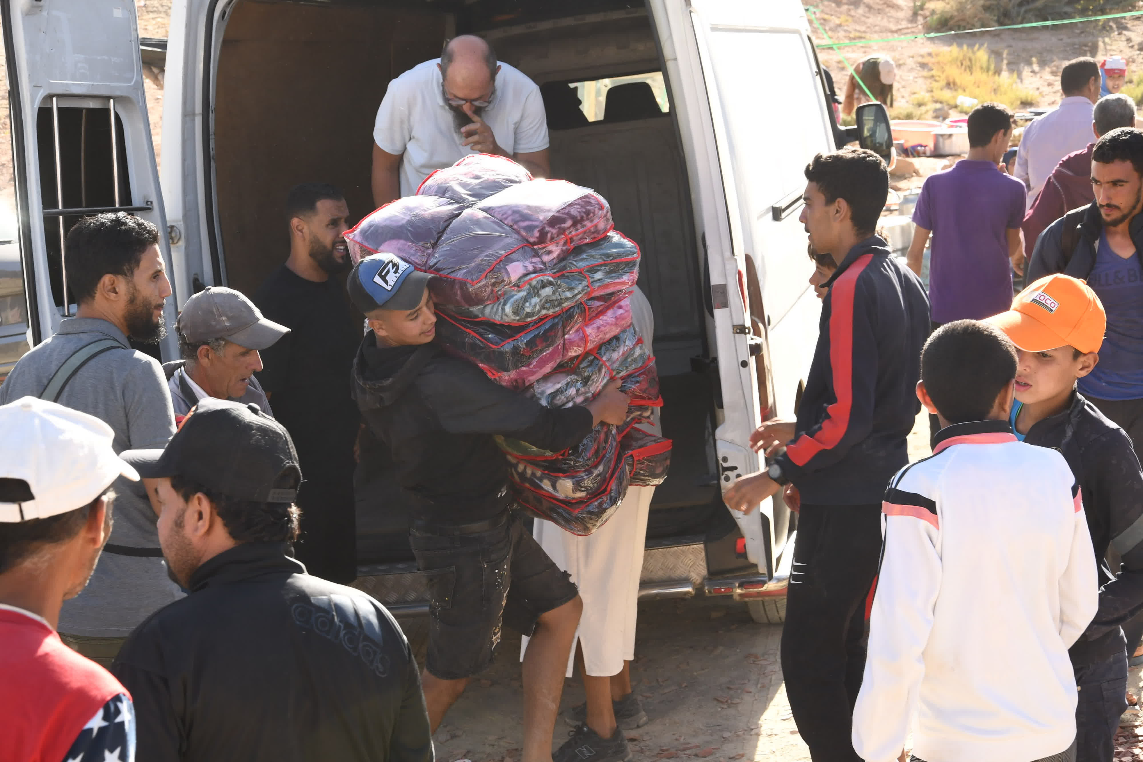 9月10日，在摩洛哥震中附近的艾茲魯村，人們搬運救援物資。（新華社）