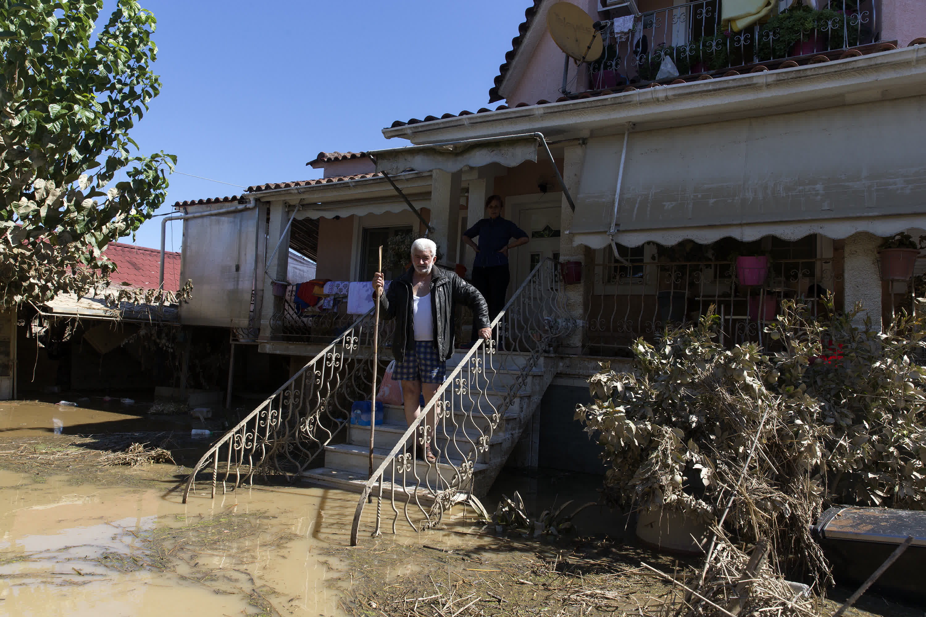 9月12日，希臘中部卡爾季察地區的一處村莊，人們站在遭遇洪水的房屋前。（新華社）