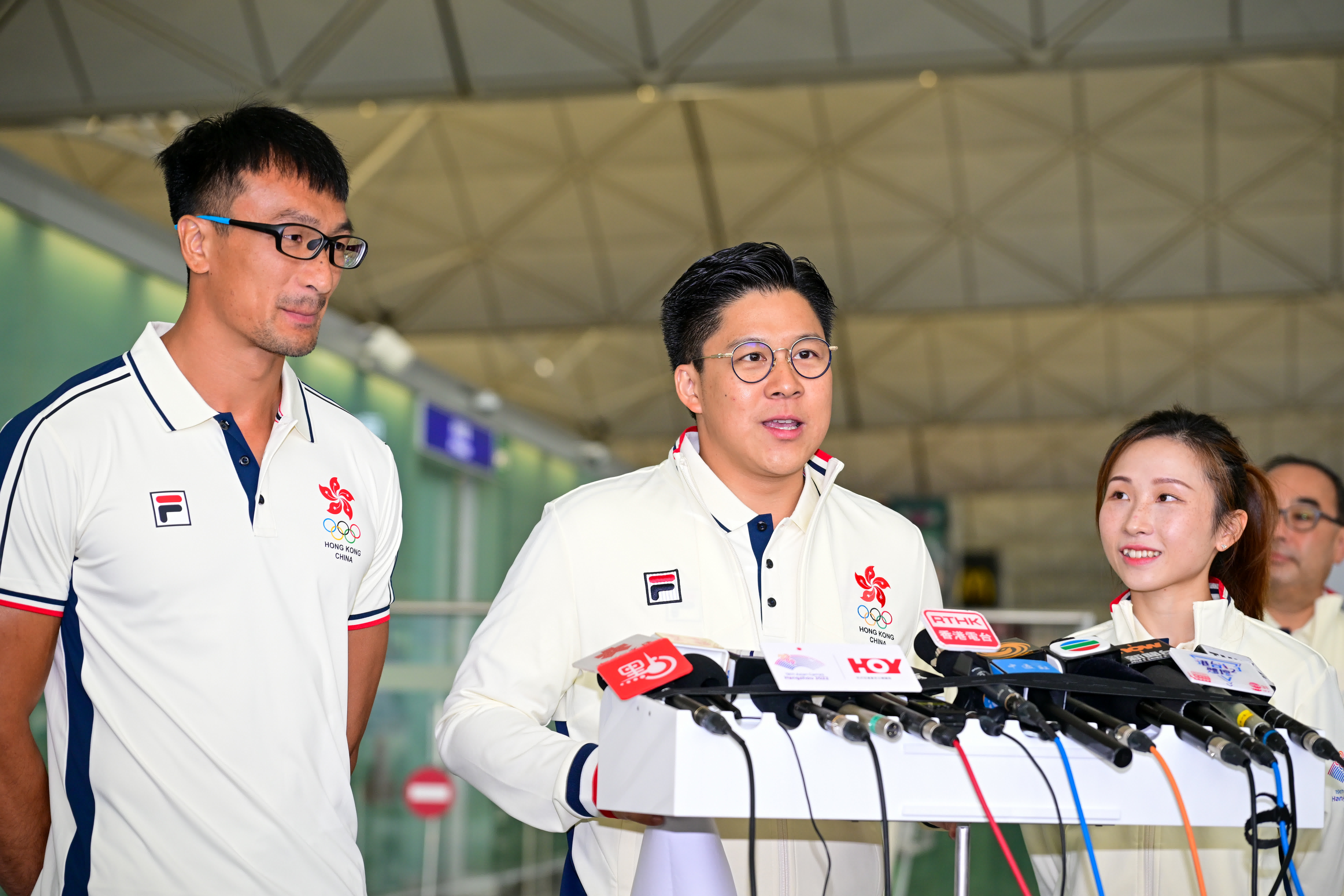 杭州亞運會中國香港代表團團長霍啟剛（中）在機場出席記者會。