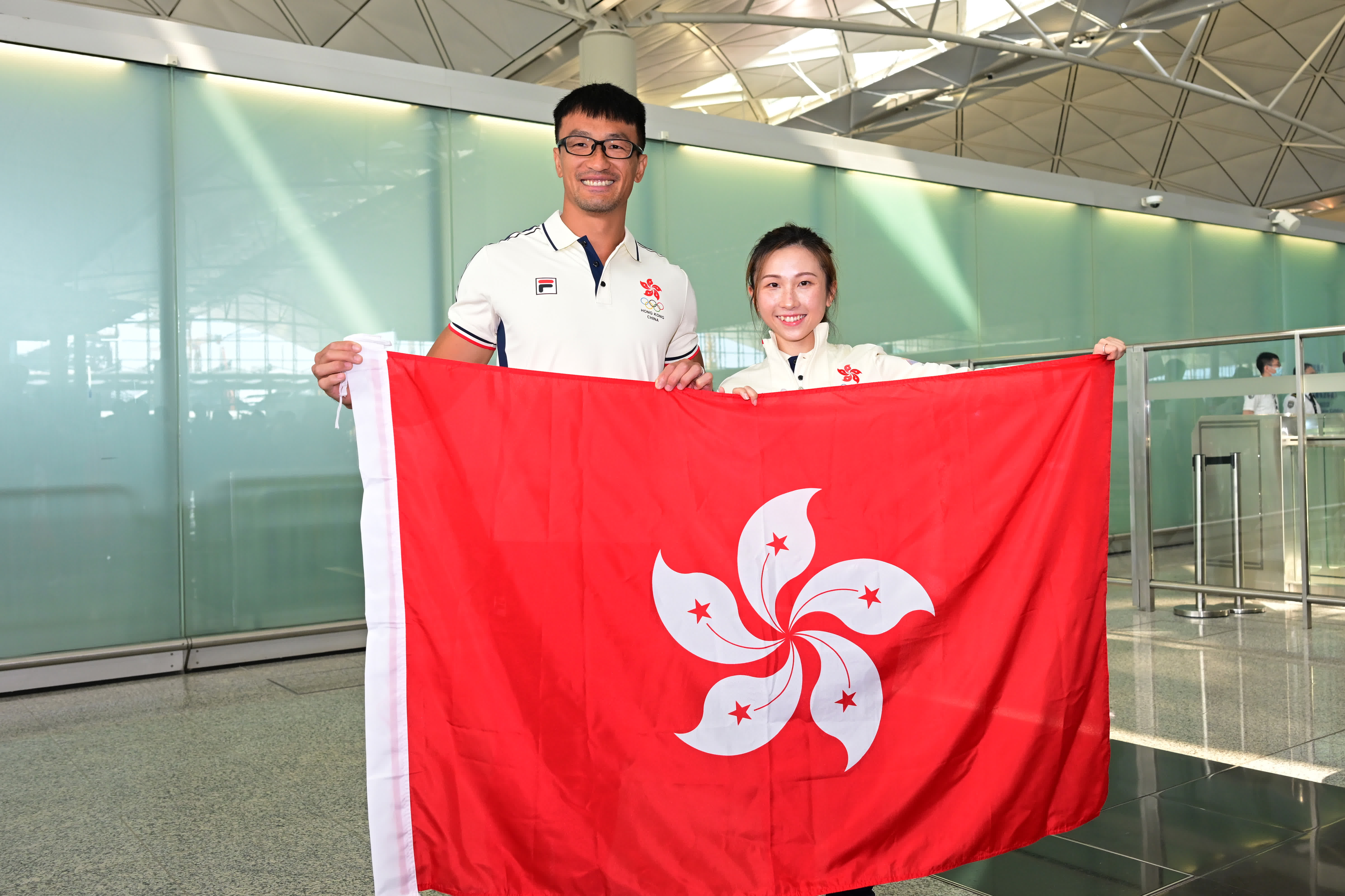 杭州亞運會中國香港代表團開幕式旗手姚錦成（左）和莫宛螢在機場合影。