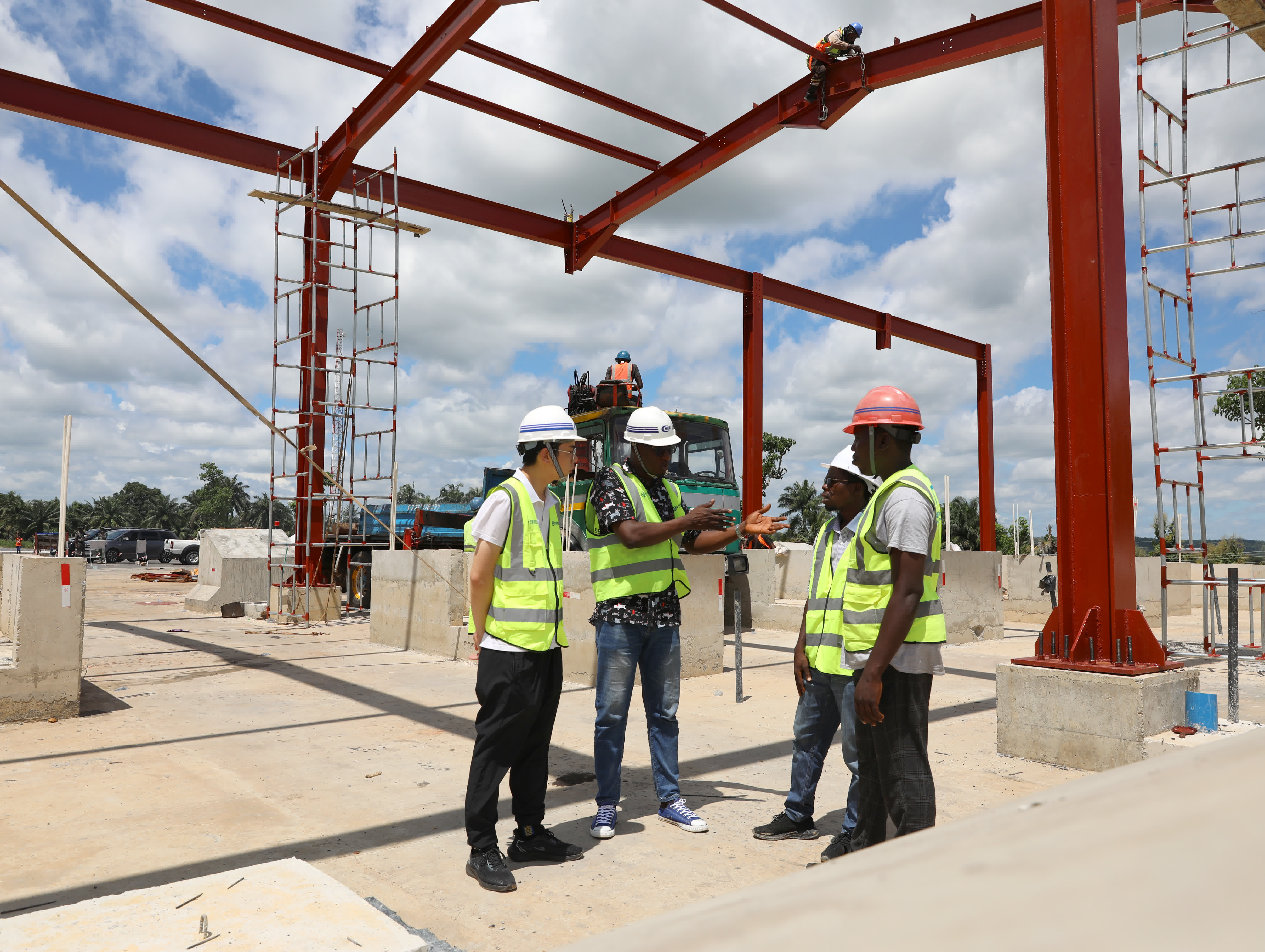 9月20日，中國工程師王蔣明（左一）與尼日利亞工程師蒂賈尼 (左二)在尼日利亞凱菲路一期工程收費站建設工地檢查工程質量。（新華社）