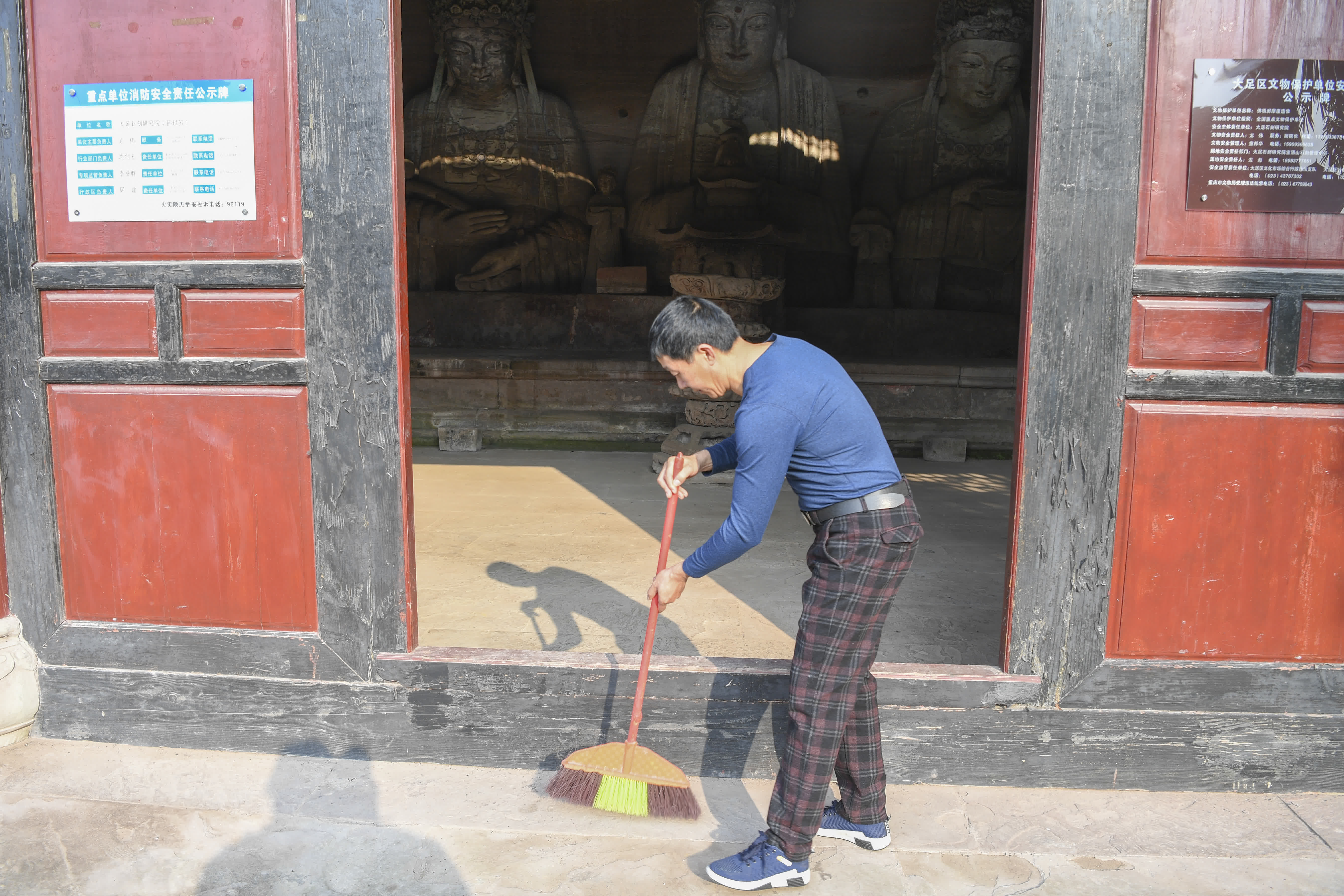 10月31日，在重慶市大足區寶頂鎮香山社區，義務文保員在佛祖岩摩崖造像文物保護點打掃衞生。（新華社）
