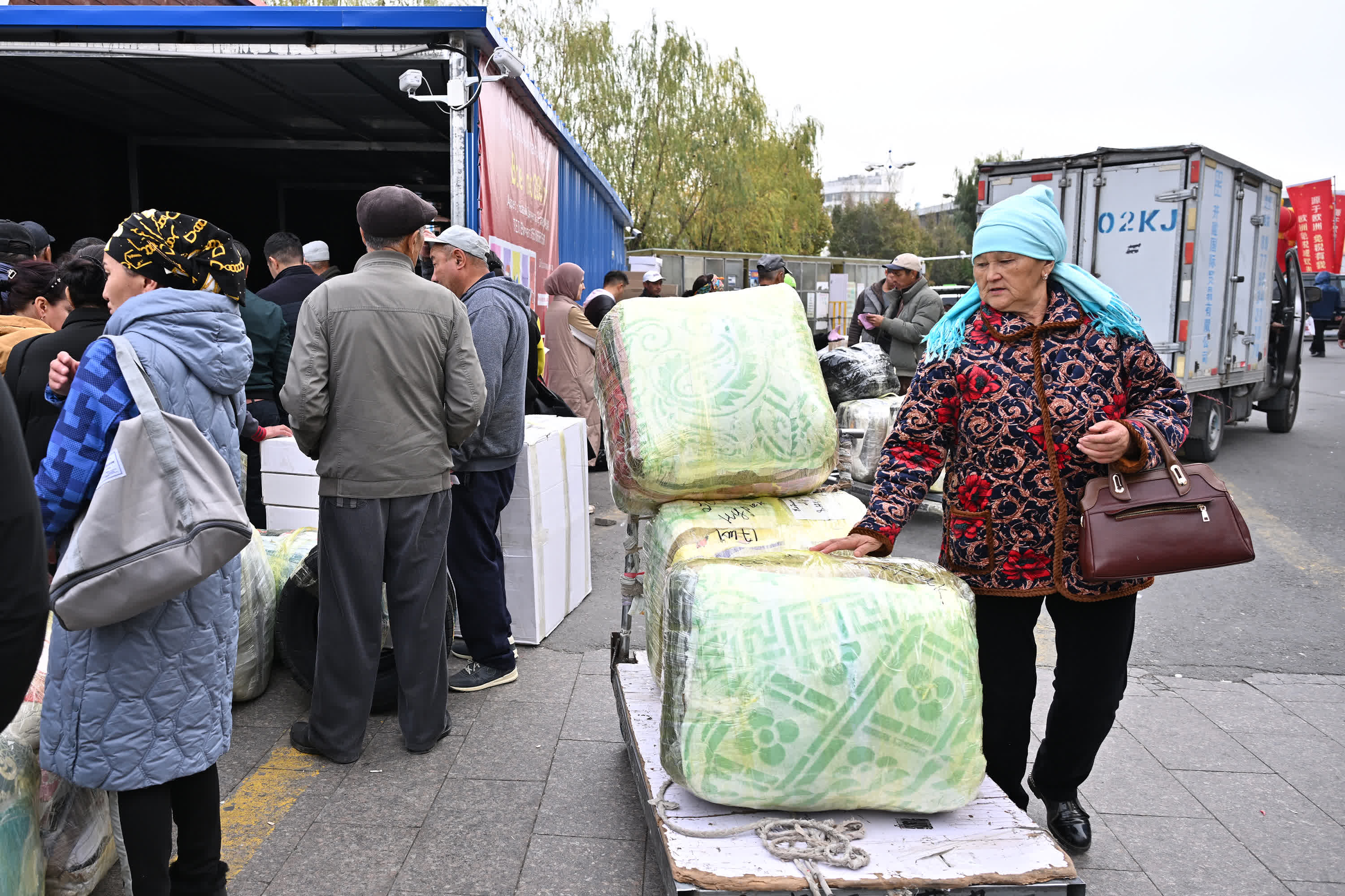  11月8日，在中哈霍爾果斯國際邊境合作中心，哈薩克斯坦的遊客將購買的貨物打包發車。（新華社）