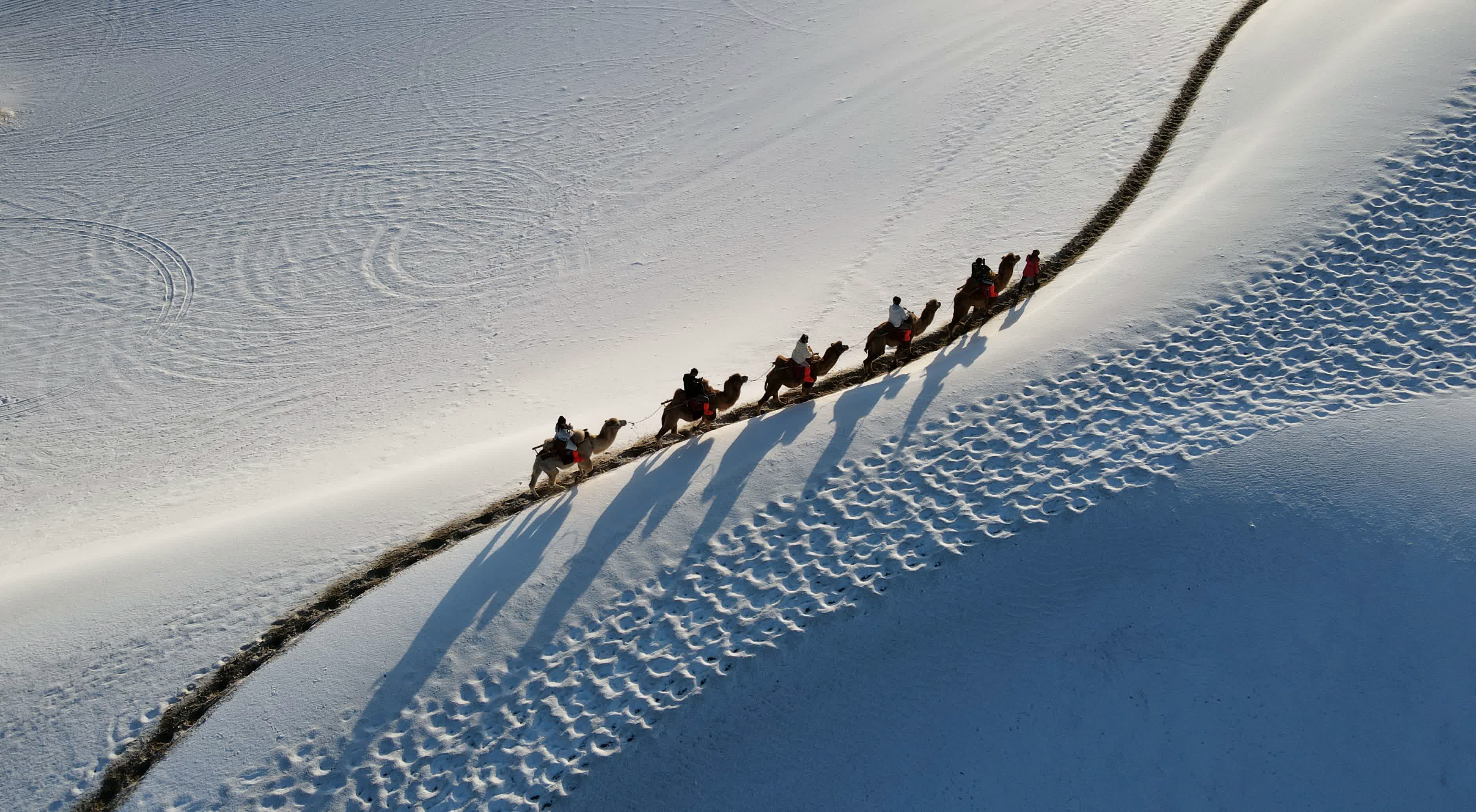 11月15日，遊客在鳴沙山月牙泉景區欣賞雪景（無人機照片）。  （  新華社）