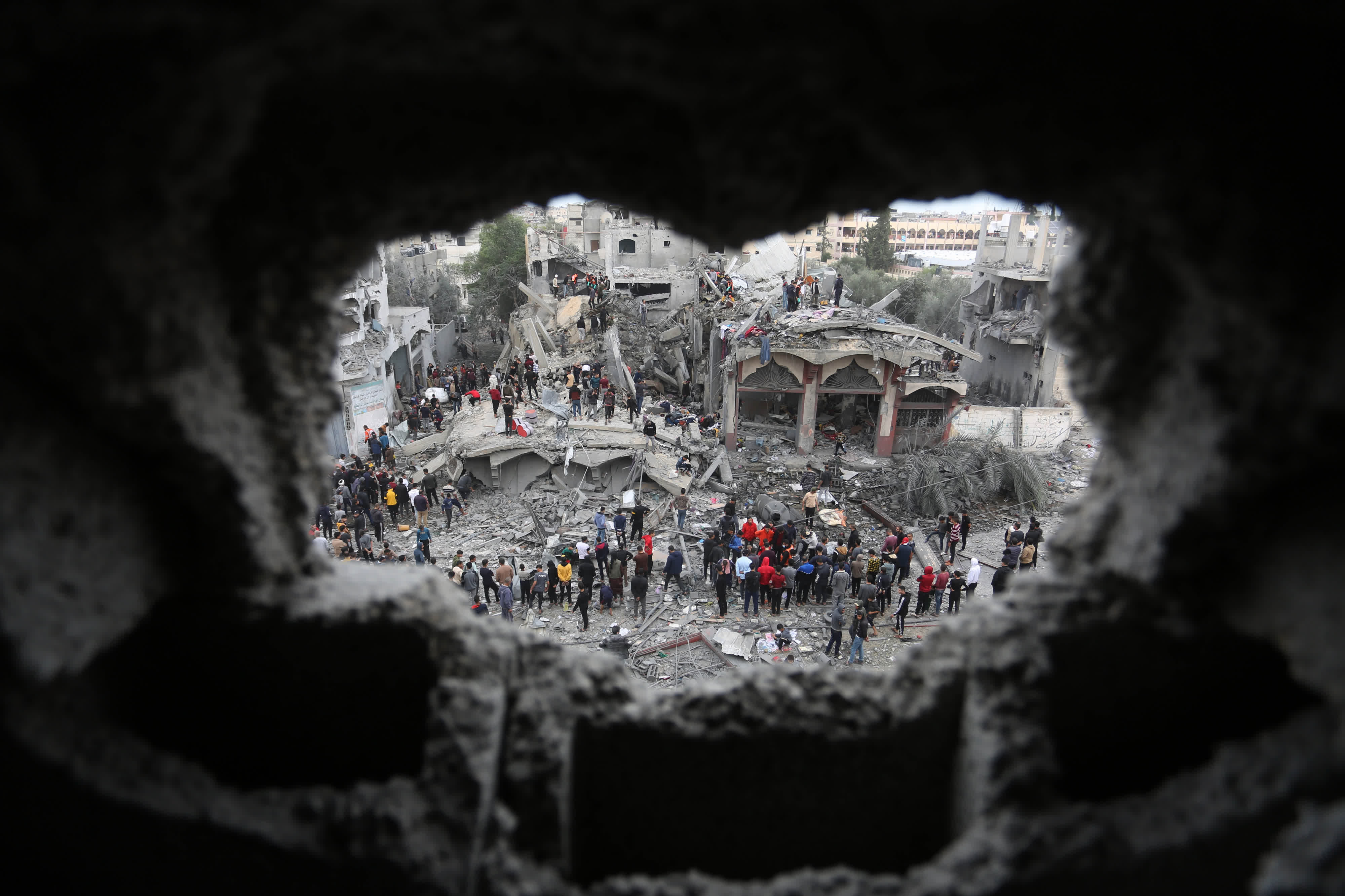   11月22日，人們在加沙地帶南部城市拉法的建築廢墟上實施救援。（新華社）