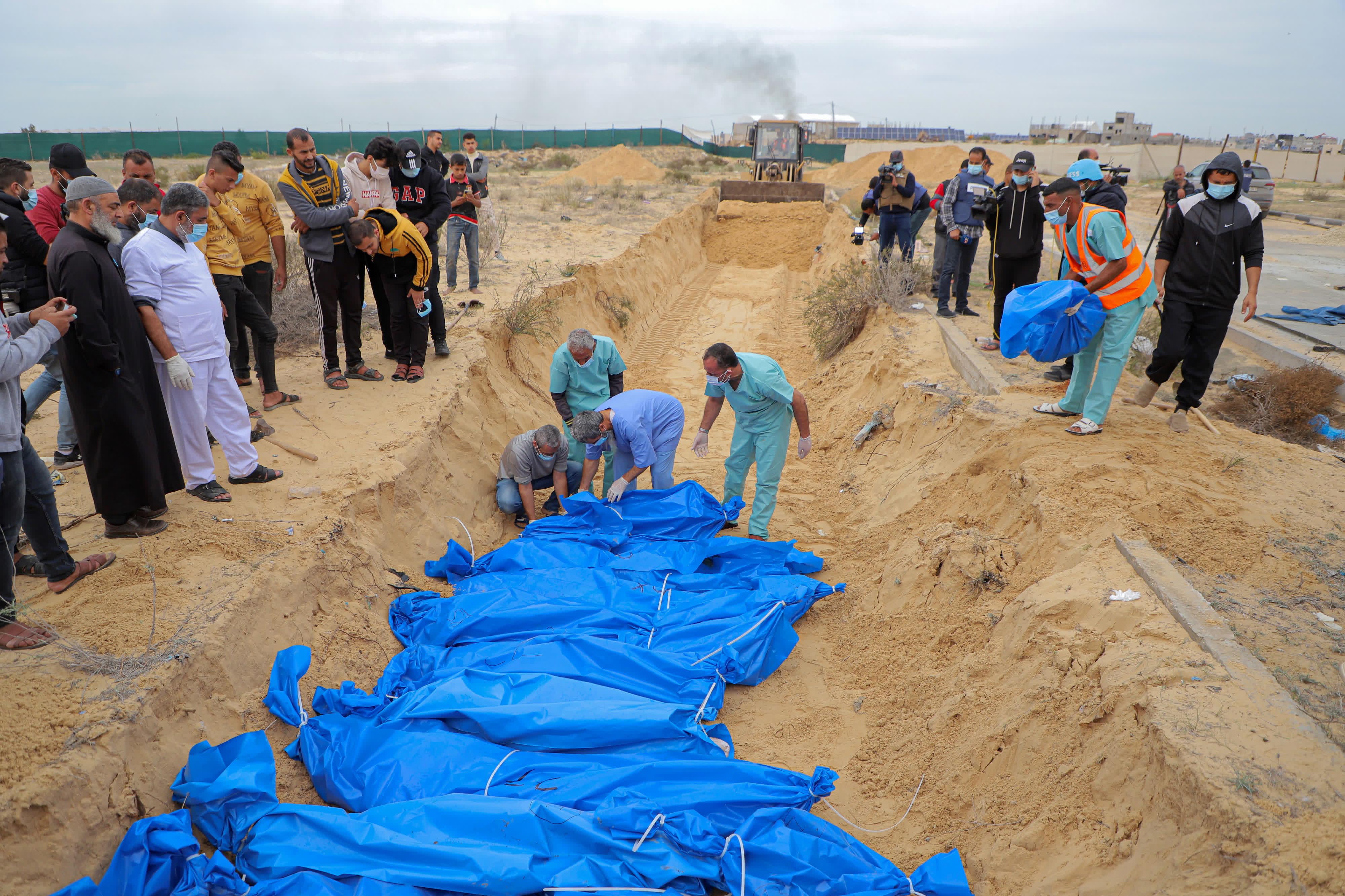 11月22日，人們在加沙地帶南部城市汗尤尼斯埋葬巴以衝突遇難者。（新華社）