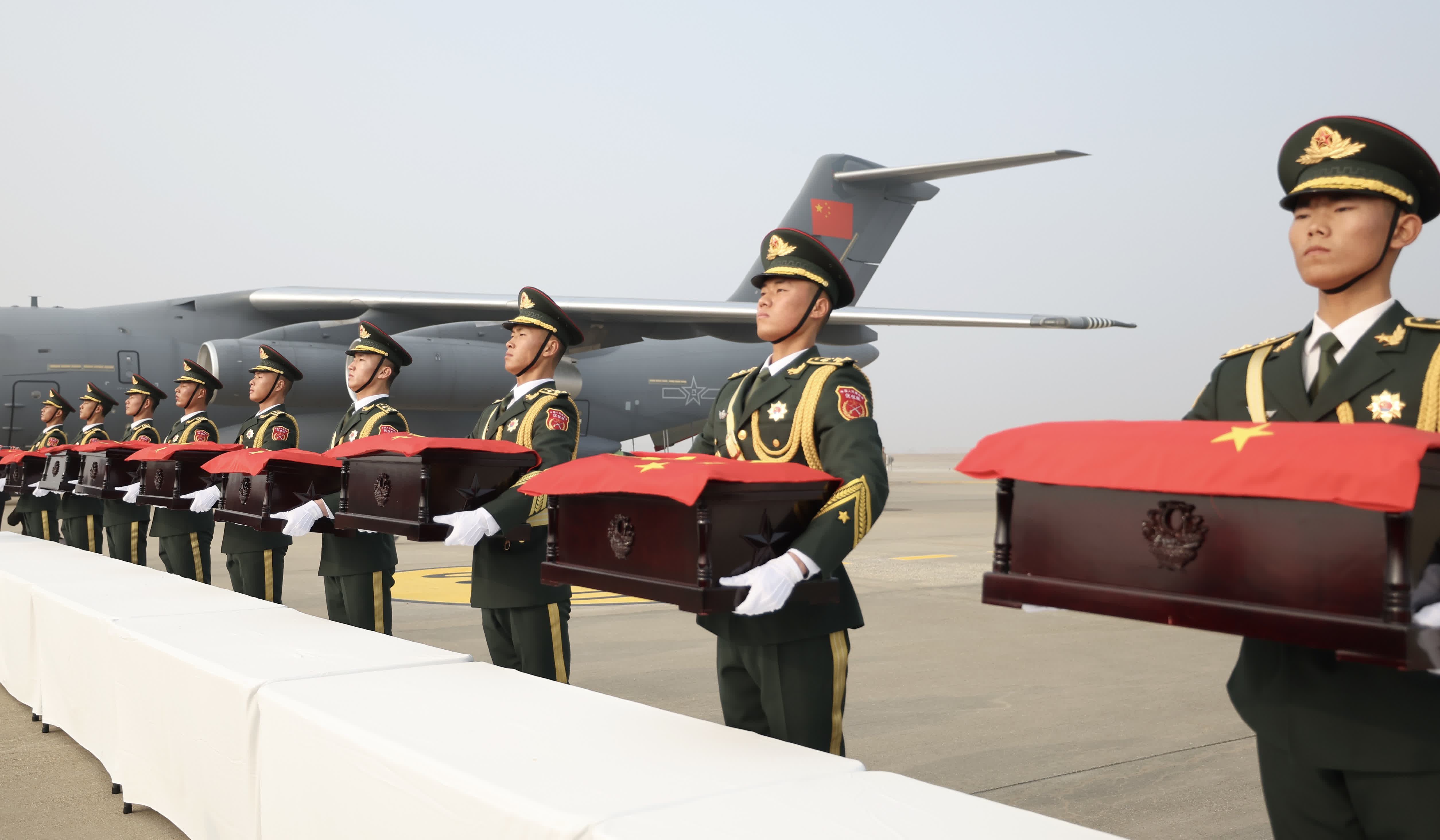 11月23日，在韓國仁川國際機場，中國人民解放軍禮兵準備護送烈士棺槨登上解放軍空軍專機。（新華社）