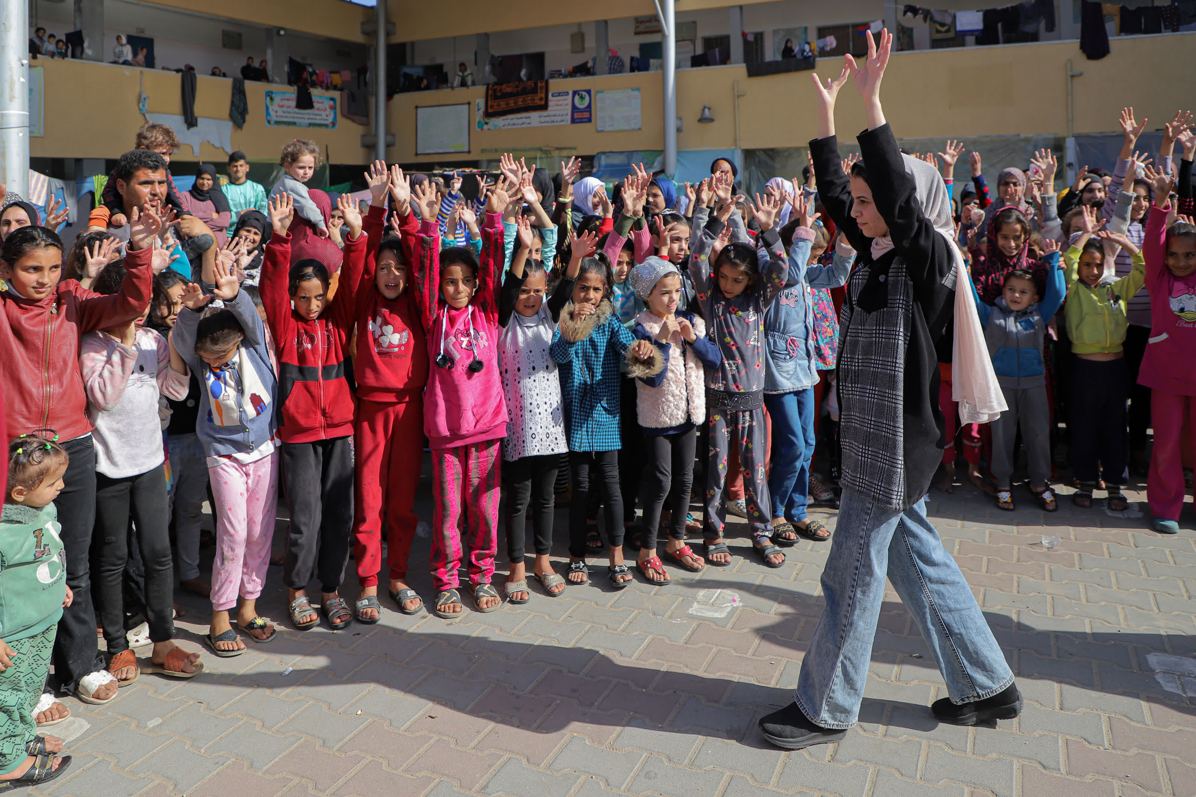 11月23日，在加沙地帶南部城市汗尤尼斯，當地志願者和兒童進行互動。（新華社）