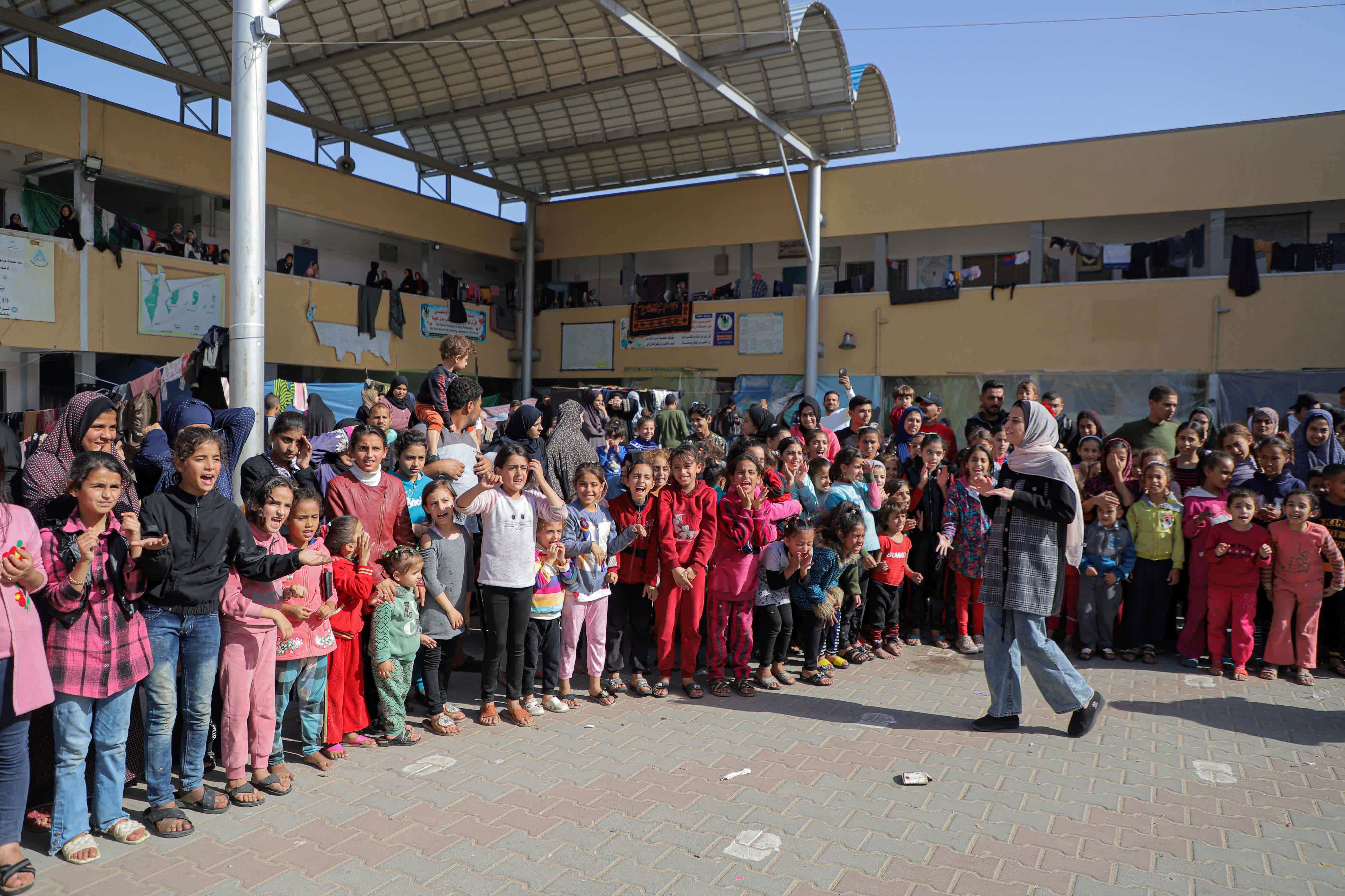  11月23日，在加沙地帶南部城市汗尤尼斯，當地志願者和兒童進行互動。（新華社）