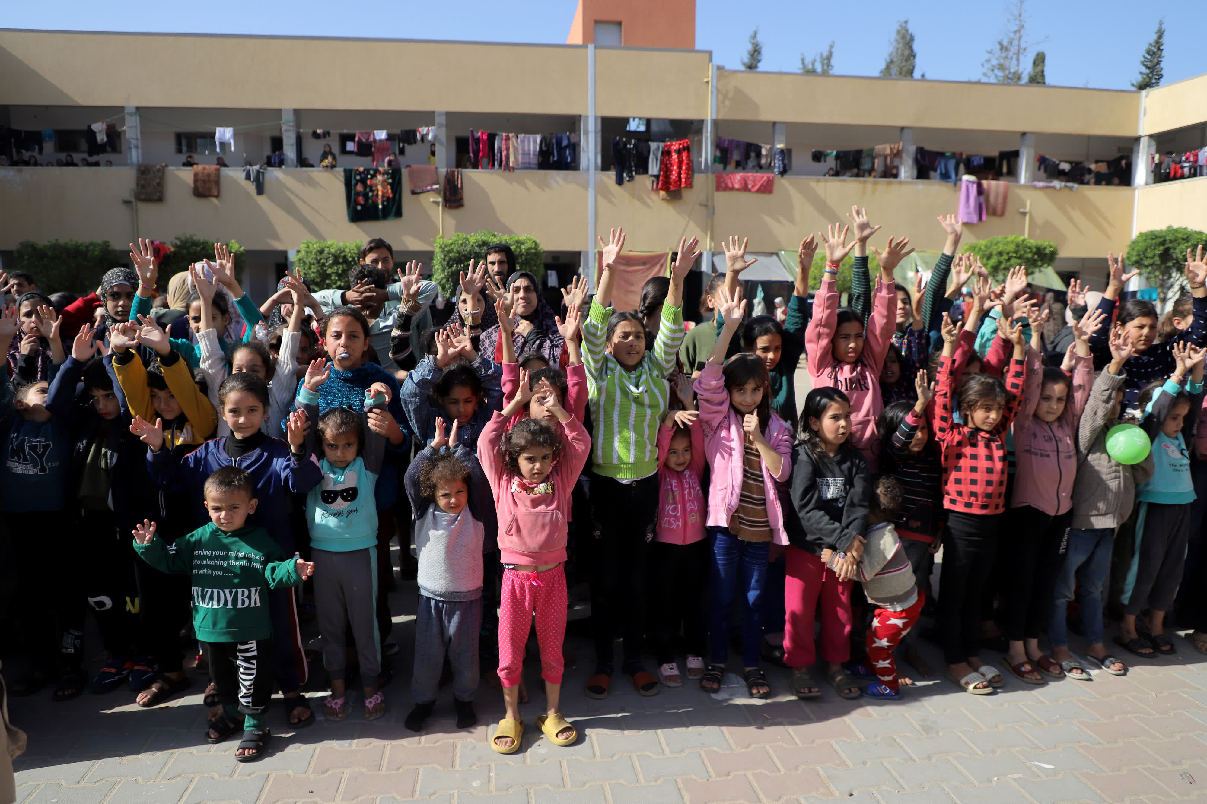 這是11月23日在加沙地帶南部城市汗尤尼斯拍攝的與當地志願者互動的兒童。（新華社）
