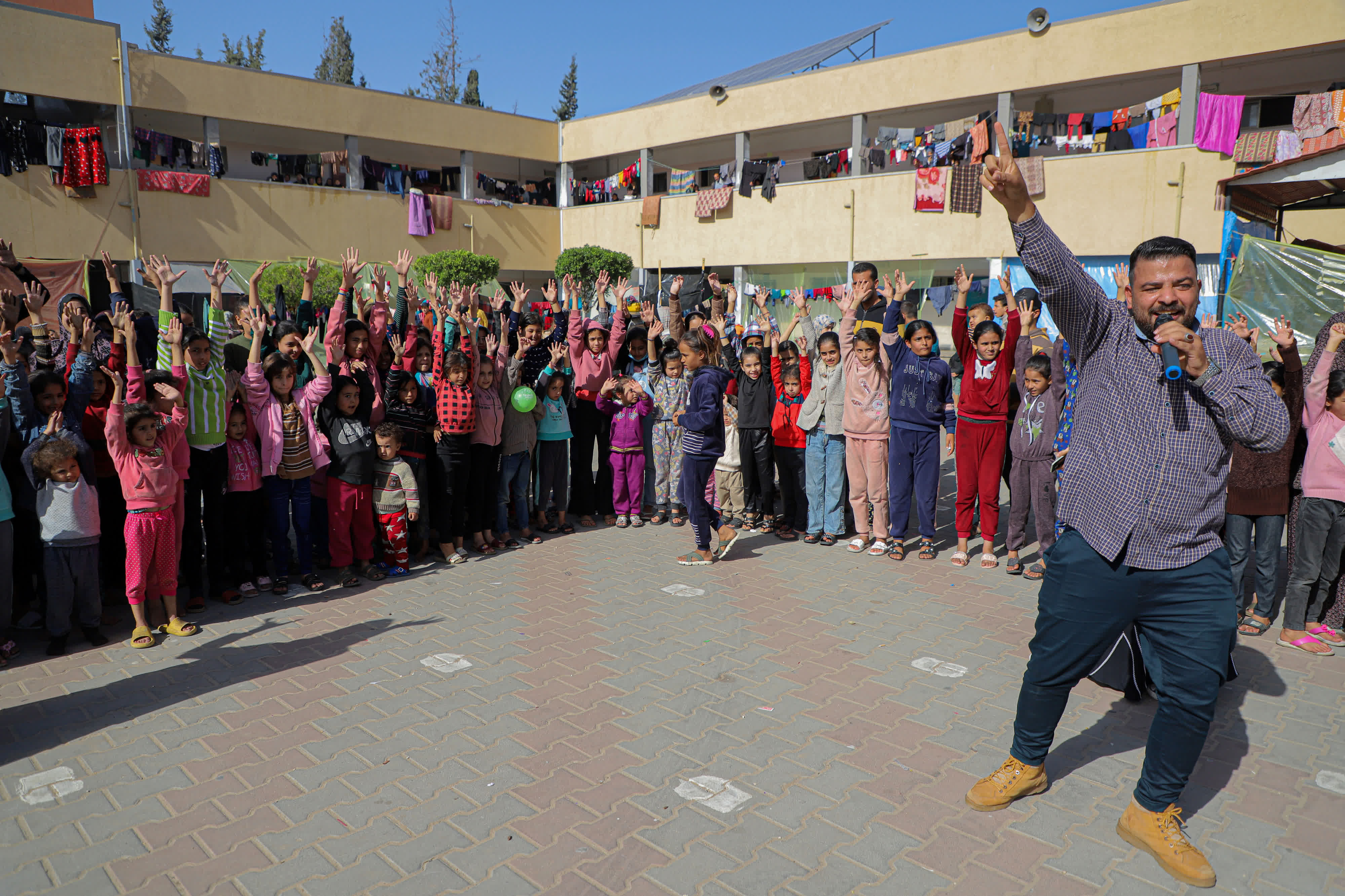  11月23日，在加沙地帶南部城市汗尤尼斯，當地志願者和兒童進行互動。（新華社）