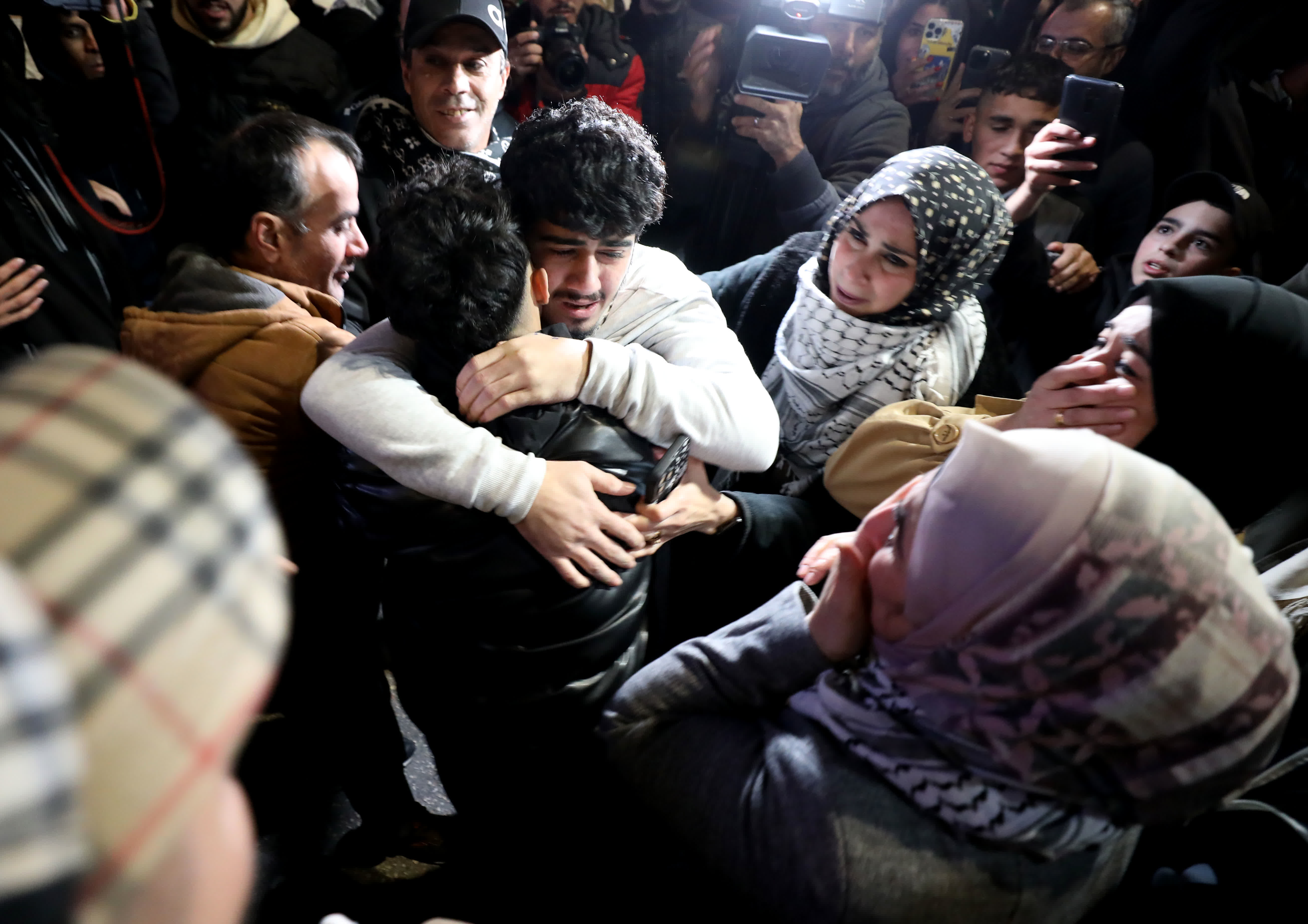 11月26日，在約旦河西岸城市拉姆安拉，獲釋的巴勒斯坦人與親人團聚。（新華社）
