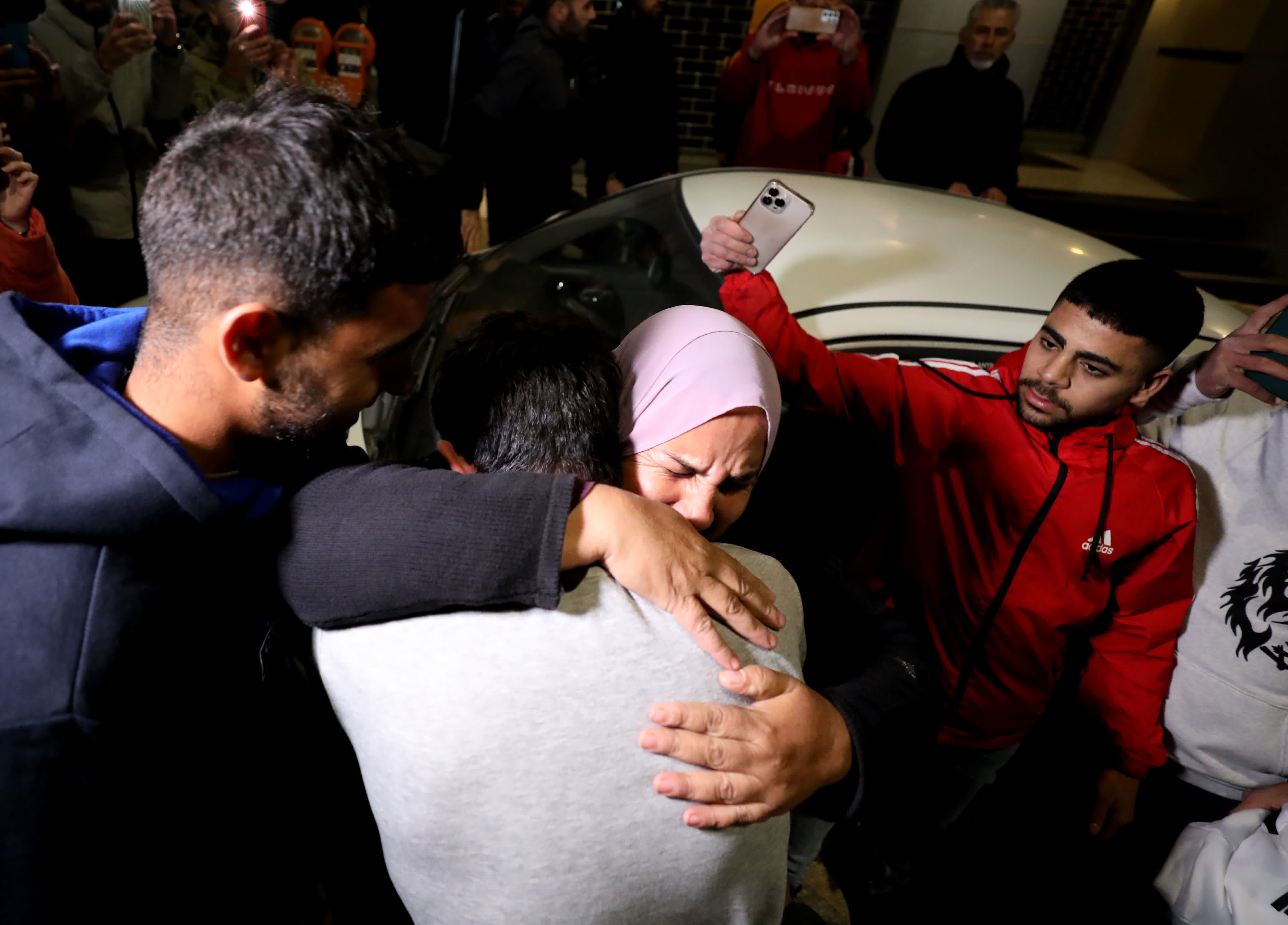 11月26日，在約旦河西岸城市拉姆安拉，獲釋的巴勒斯坦人與親人團聚。（新華社）